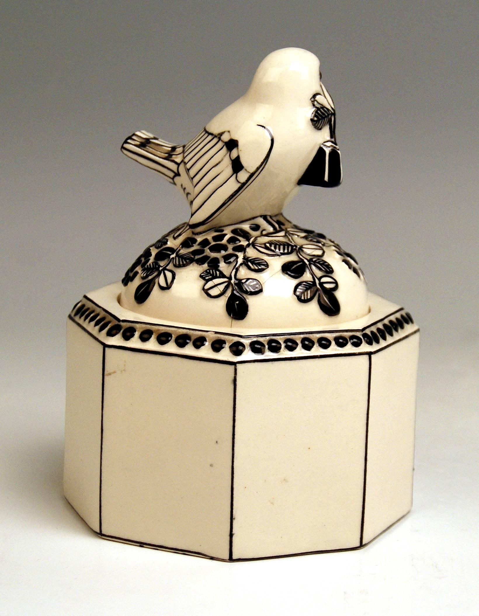 Detailed description: 
Ceramics box (eight-sided), with sparrow holding a flower's twig in beak / the bird's figurine is attached to lid
DESIGN: Michael Powolny, circa 1907

cream white and black shaded 
The domed lid of box is abundantly