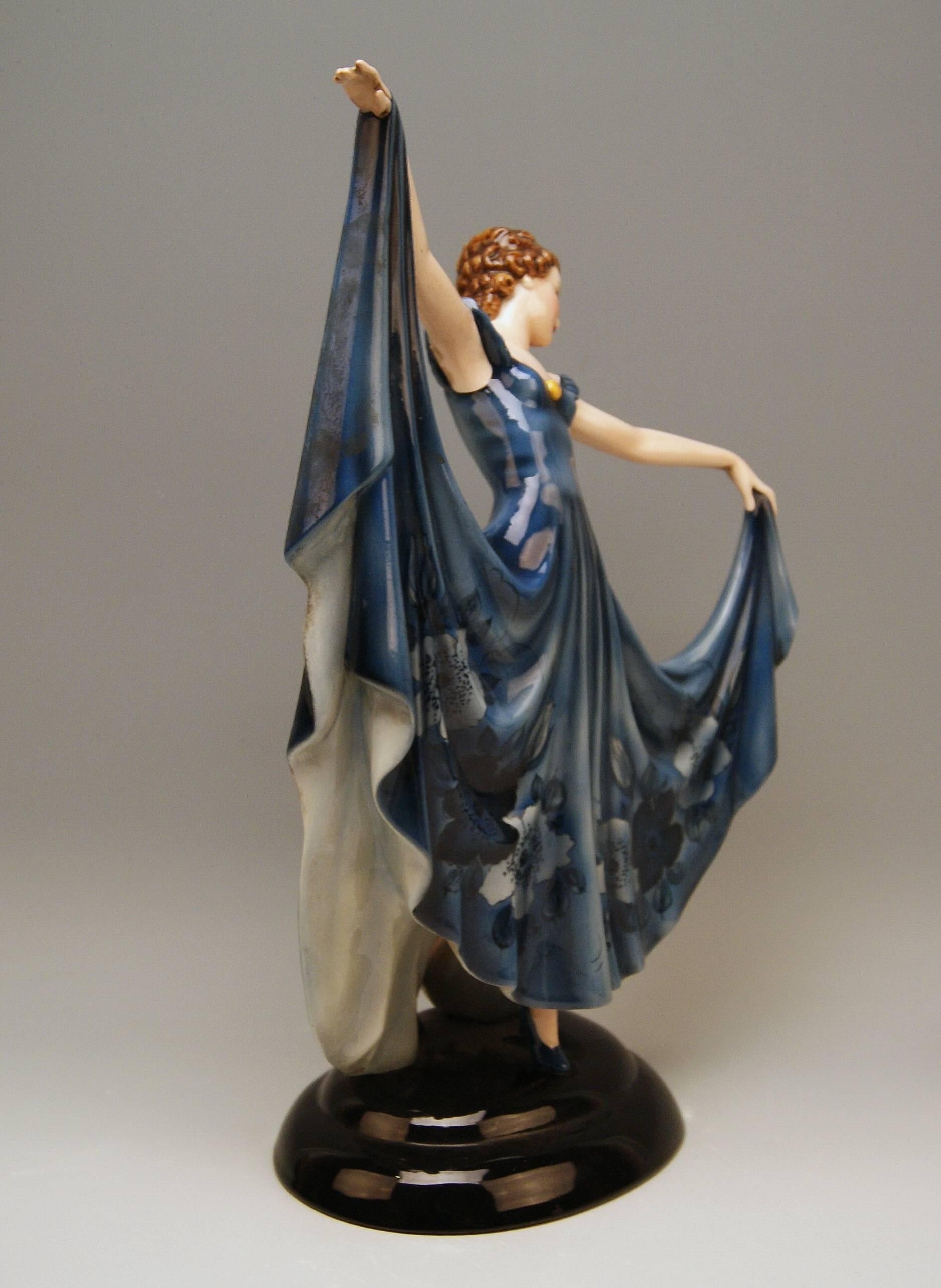 Art Deco Keramos lady dancer clad in blue dress
Designed by Stefan Dakon (1904 – 1997) / made circa 1950

Hallmarked at reverse side:
Keramos (Wien / = Vienna) / Made in Austria
stamp mark shaped as coat of arms with banderole in which letters