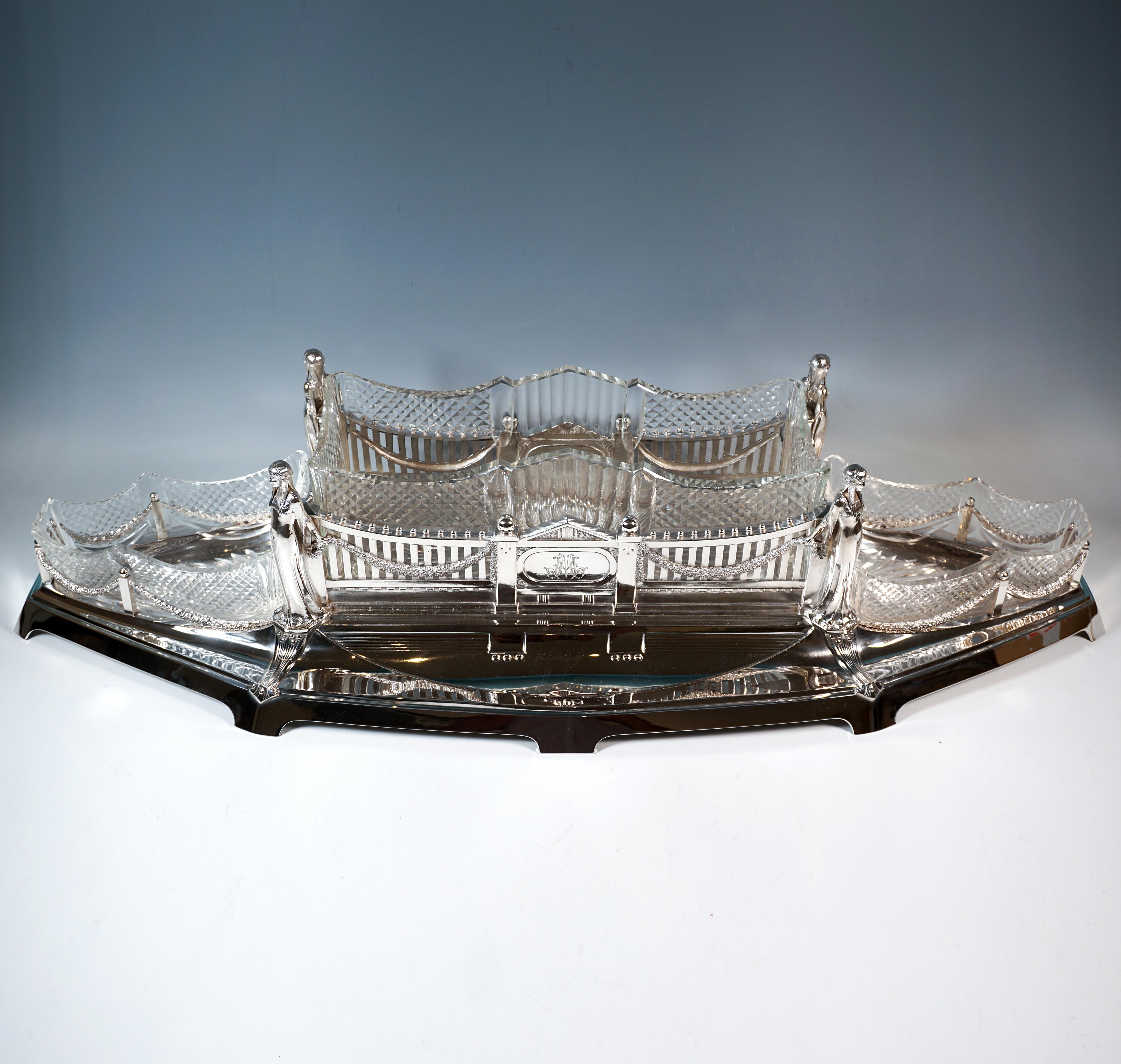 Elegant récipient festif en argent avec un design architectural en trois parties :
Base allongée en forme de bateau aux côtés bas et évasés, découpée à la base et reposant sur huit points au sol, donnant au corps une légèreté flottante. Un corps