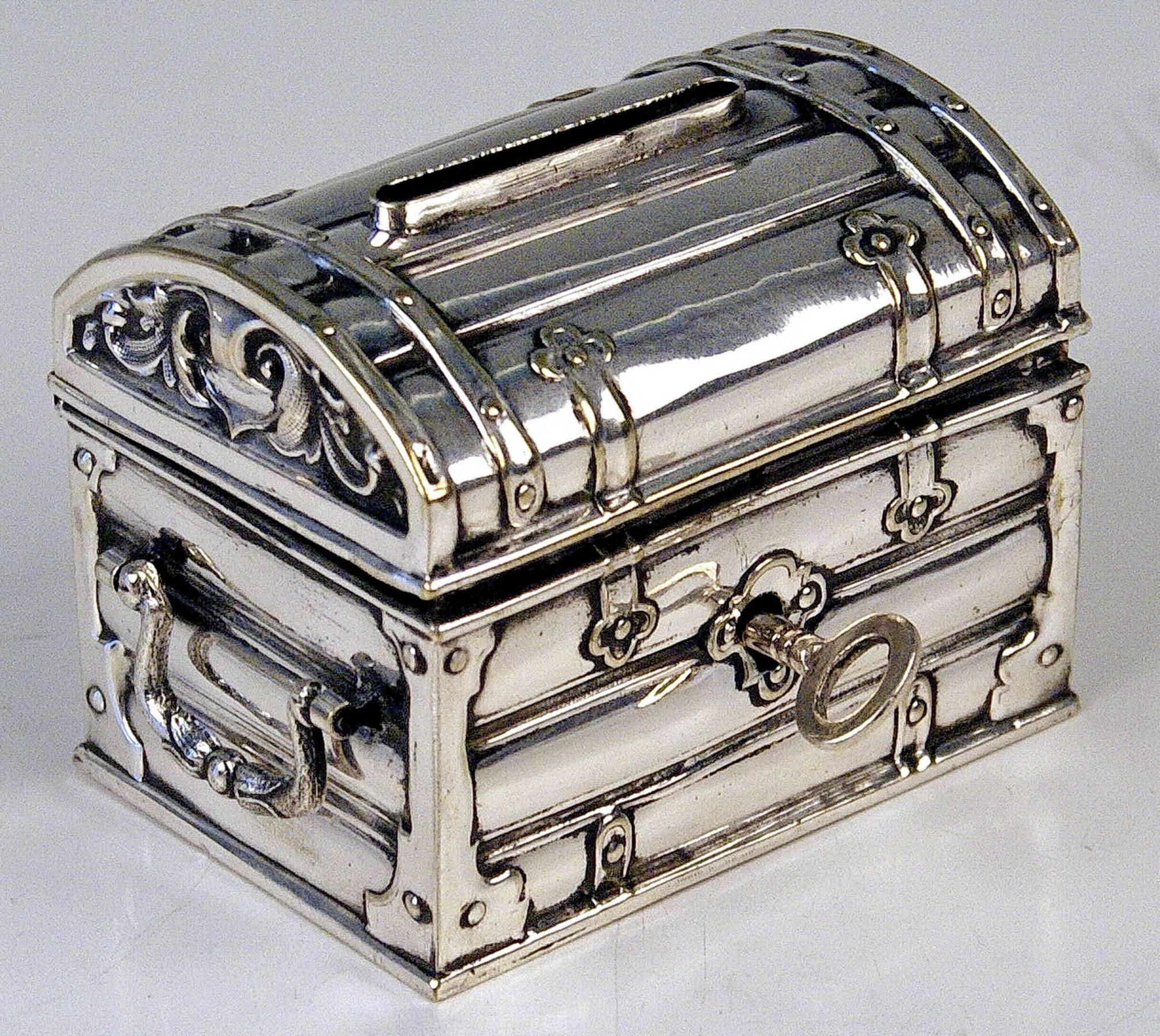 Austrian silver money box or piggy bank
manufactured during later 19th century period made circa 1880-1885.

Excellently made lidded money box (piggy bank) shaped as treasure chest having movable handles at lateral sides. Original key existing /
