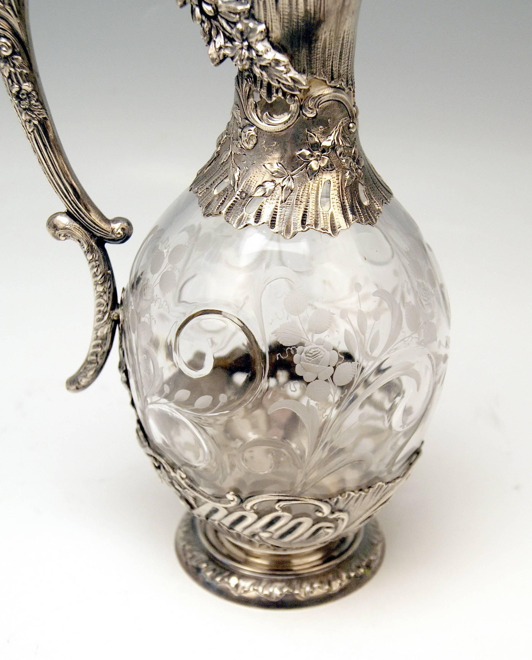 A pair of glass decanters (Carafes) with gorgeous silver mountings transition style from Historicism towards Art Nouveau period.

The decanters are made of glass, partially covered with gorgeous silver 800 mountings.

Hallmarked: 
Master's mark