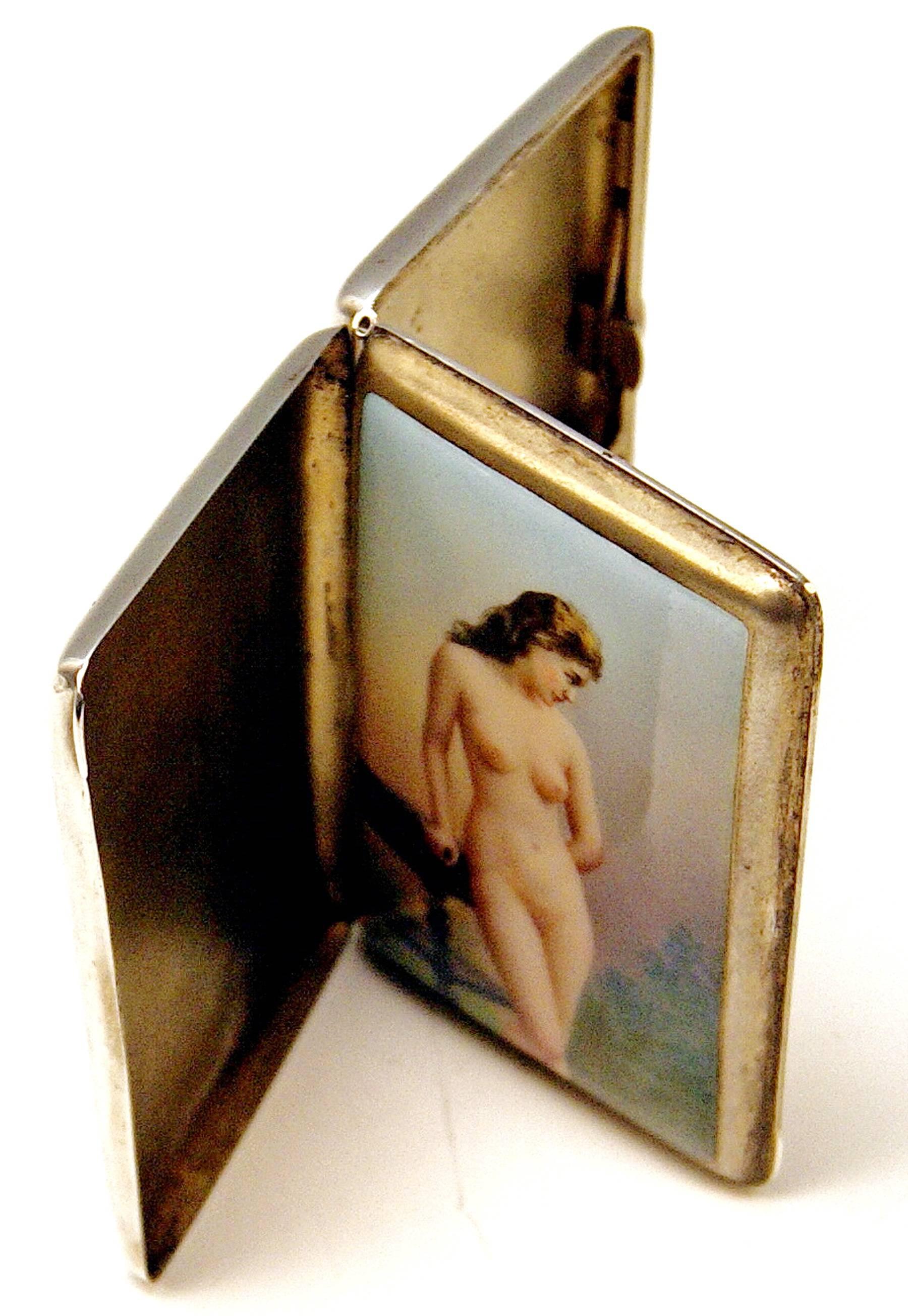 Very interesting silver 800 cigarette box or case with enamel painting covering inner lid: Lady nude.

The inner lid is decorated with stunning enamel picture - following scene is painted there: A handsome lady nude supports herself at table with