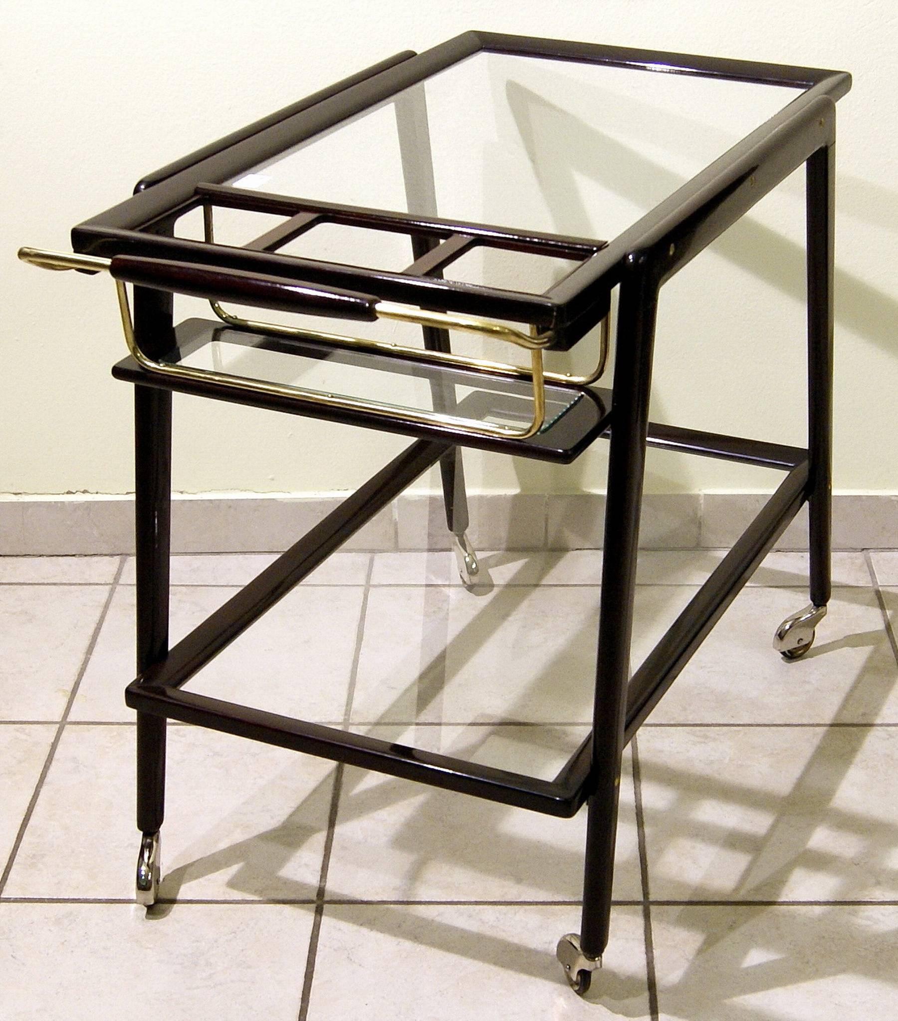Most elegant serving trolley / bar cart, Vienna, made circa 1940-1950.
 
Serving trolley of finest manufacturing quality.
Dark mahogany stained / refurbished by hand.
The serving trolley's shelves are made of glass / it stands on original small