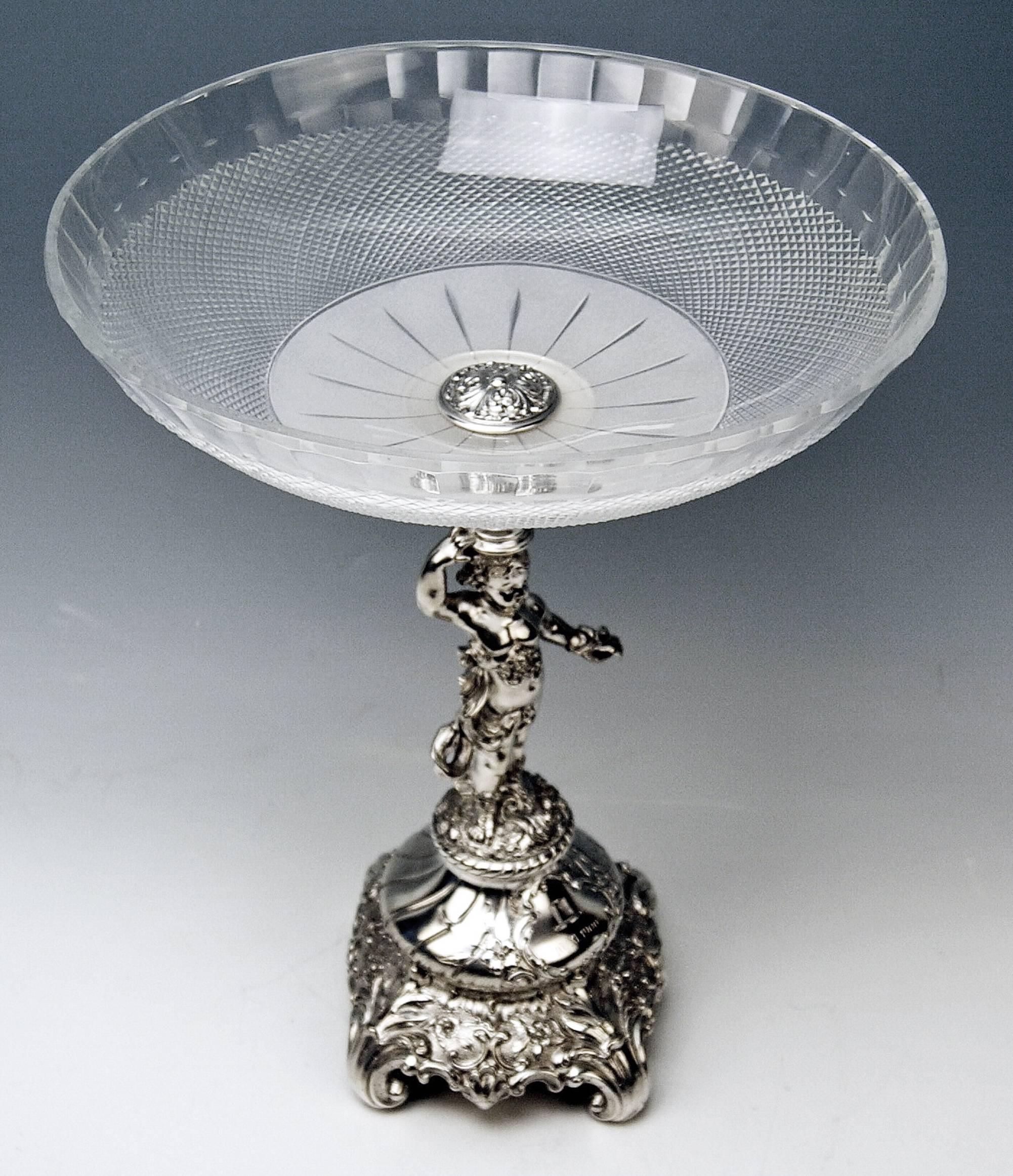 Silver Austrian tall centrepiece made in style of Historicism with original round glass platter.
Dedication visible: A topper/high hat, beneath it there is a date engraved, 10/XI 1900 which means 11-10-1900.

The stalk of centrepiece is