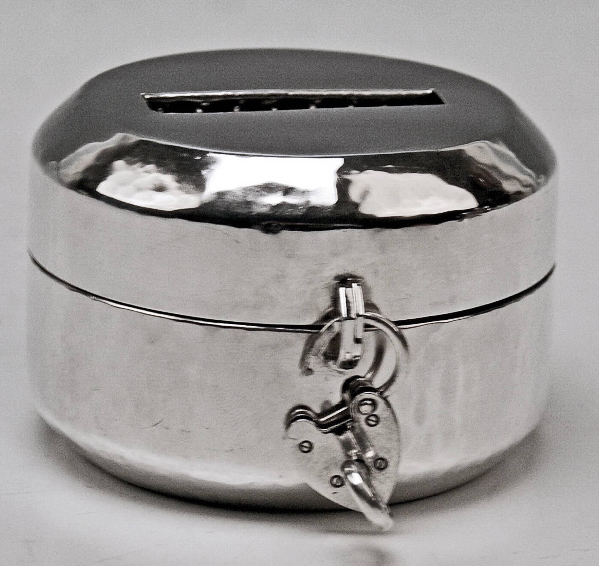 Hucha o alcancía de plata alemana 
fabricado durante el primer cuarto del siglo XX / fabricado hacia 1930

Hucha Art Decó (alcancía) de excelente factura, con forma de caja redonda con tapa y candado que debe cerrarse con llave (¡existe la llave