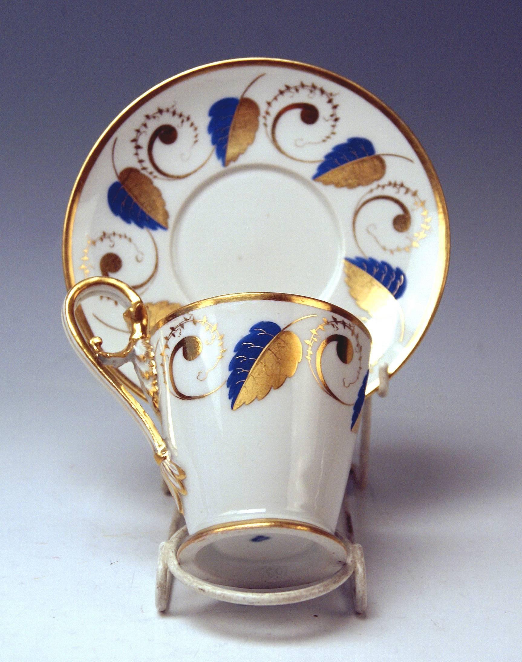 Tapering cup of conical form type with hoisted handle and saucer, both decorated with golden-blue ornaments.

Vienna / Old Imperial Austrian Porcelain Manufactory
(= Alt Wien / Kaiserliche Porzellan Manufaktur)
dated
