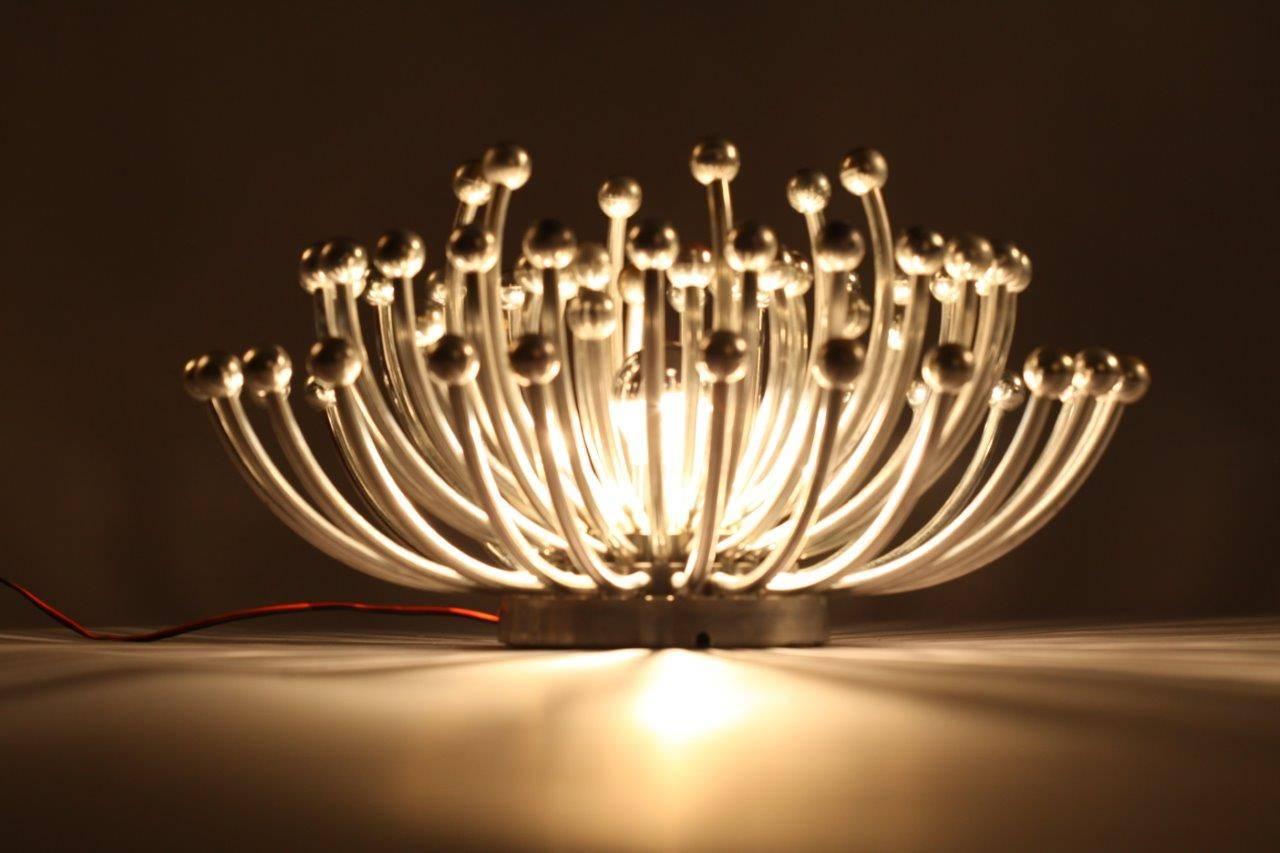 Iconic Space Age light fixture by Italy’s Studio Tetrarch for Valenti can be used as a ceiling flush mount or large wall-mounted light, circa 1969. Single center light with chrome crown light bulb is surrounded by radiating pistil arms. Chrome