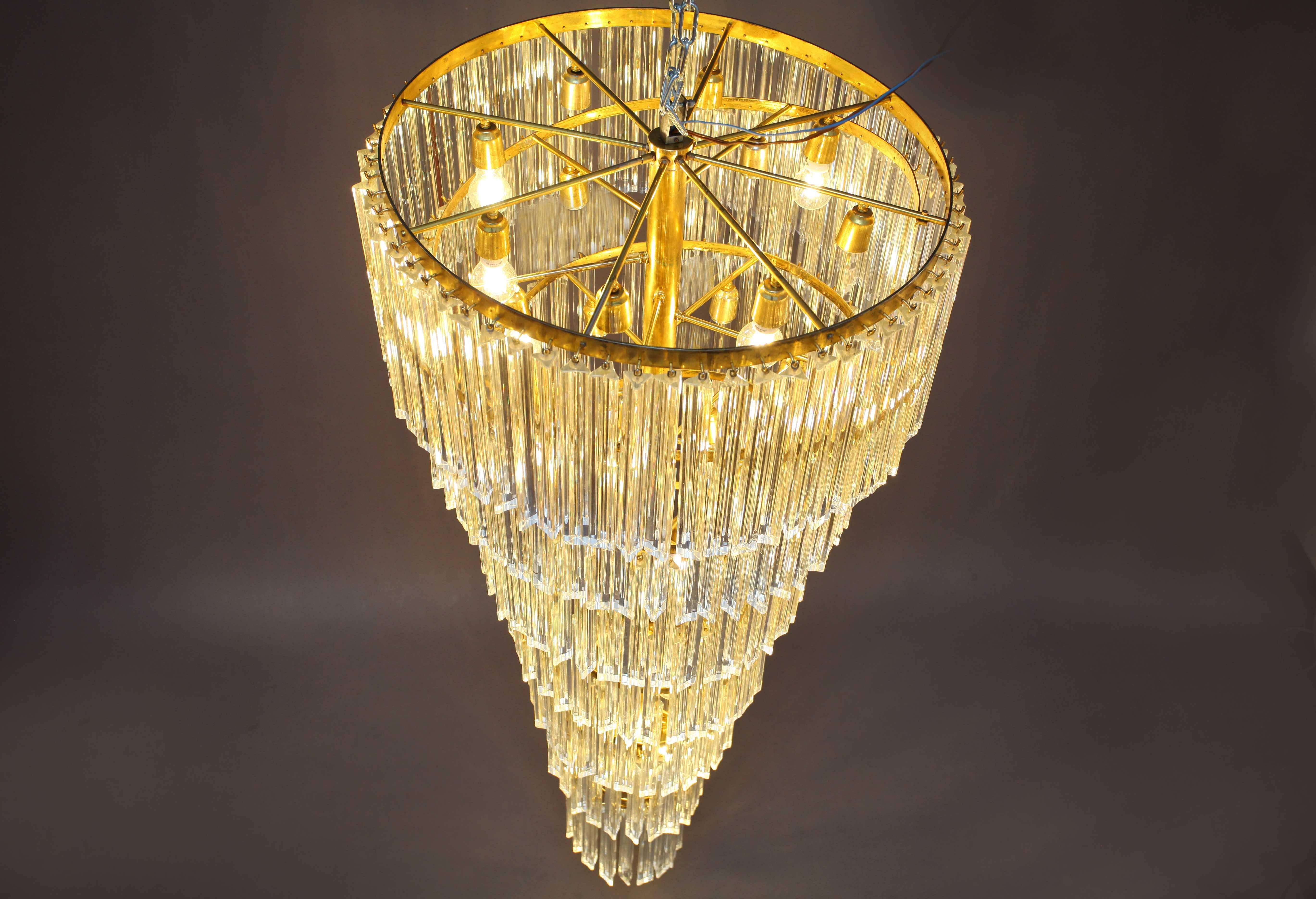 Italian spiral crystal glass chandelier,
manufacturer Venini Murano, circa 1960s.
Each of the prisms are solid glass measuring 11.8 inches each.
They hang from hooks into a spiral brass frame, as pictured.
28 bulb sockets each 60 watt max.
Measures: