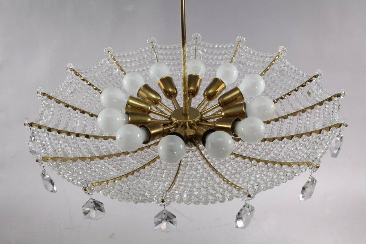 Crystal glass hanging lamp,
manufacture Rupert Nikoll,
Vienna, 1950.
Brass frame, faceted crystals drops and crystal balls.
12 E 27 bulb sockets each max. 60 Watt.
The length of the stem can be altered to any size for free