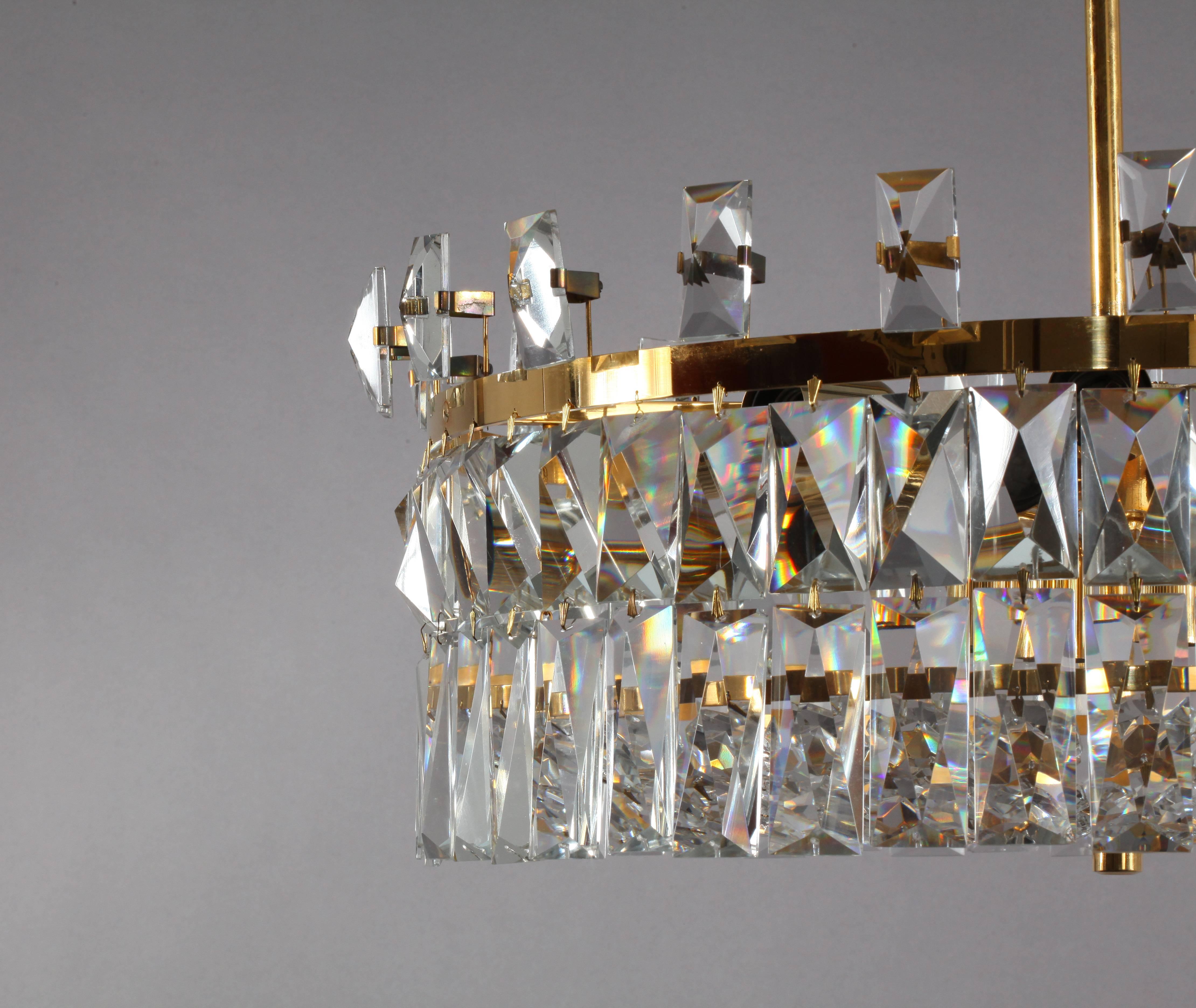 Huge crystal glass chandelier,
Oswald Haerdtl for the Feldkirch Cityhall, Austria.
Manufactured by Lobmeyer, Vienna, 1972.
Three tiers of hanging faced crystal glass, gilded brass,
12 E 27 bulb sockets,
Four E 14 centre bulb sockets.
Two