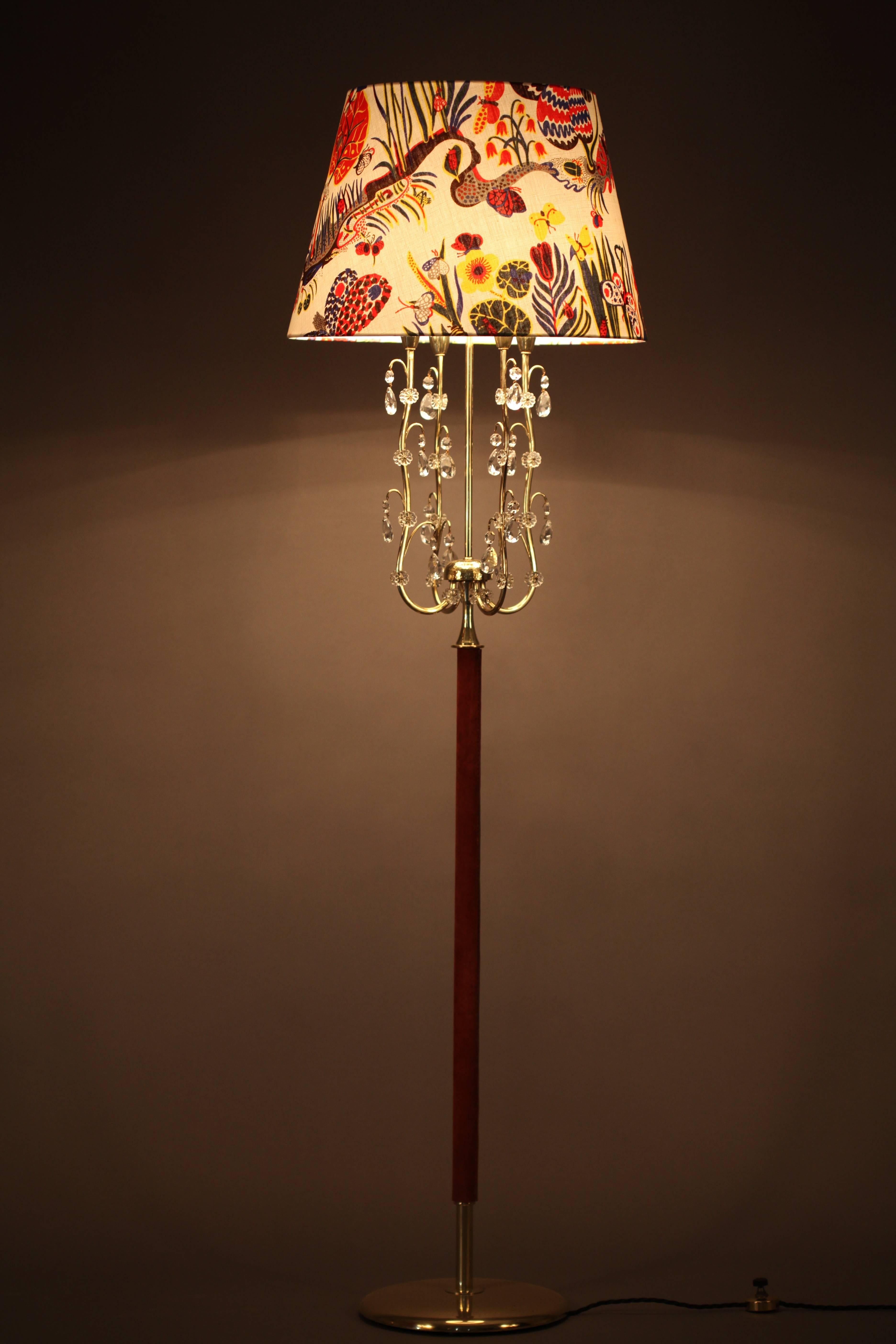 Floor lamp.
designed by Rupert Nikoll,
Vienna, 1950.
Round brass base, leather stamp, five bulb sockets,
crystal glass parts.
shade with Josef Frank fabric.
