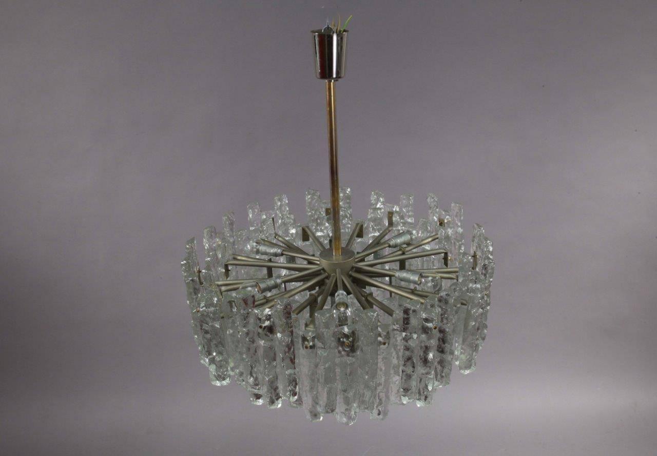 A tiered glass chandelier on a chrome frame by J.T. Kalmar, Austrian, 1972. Height 48inch, Diameter 25inch, 24 E14 bulbs.
The length of the stem can be altered to any size for free.