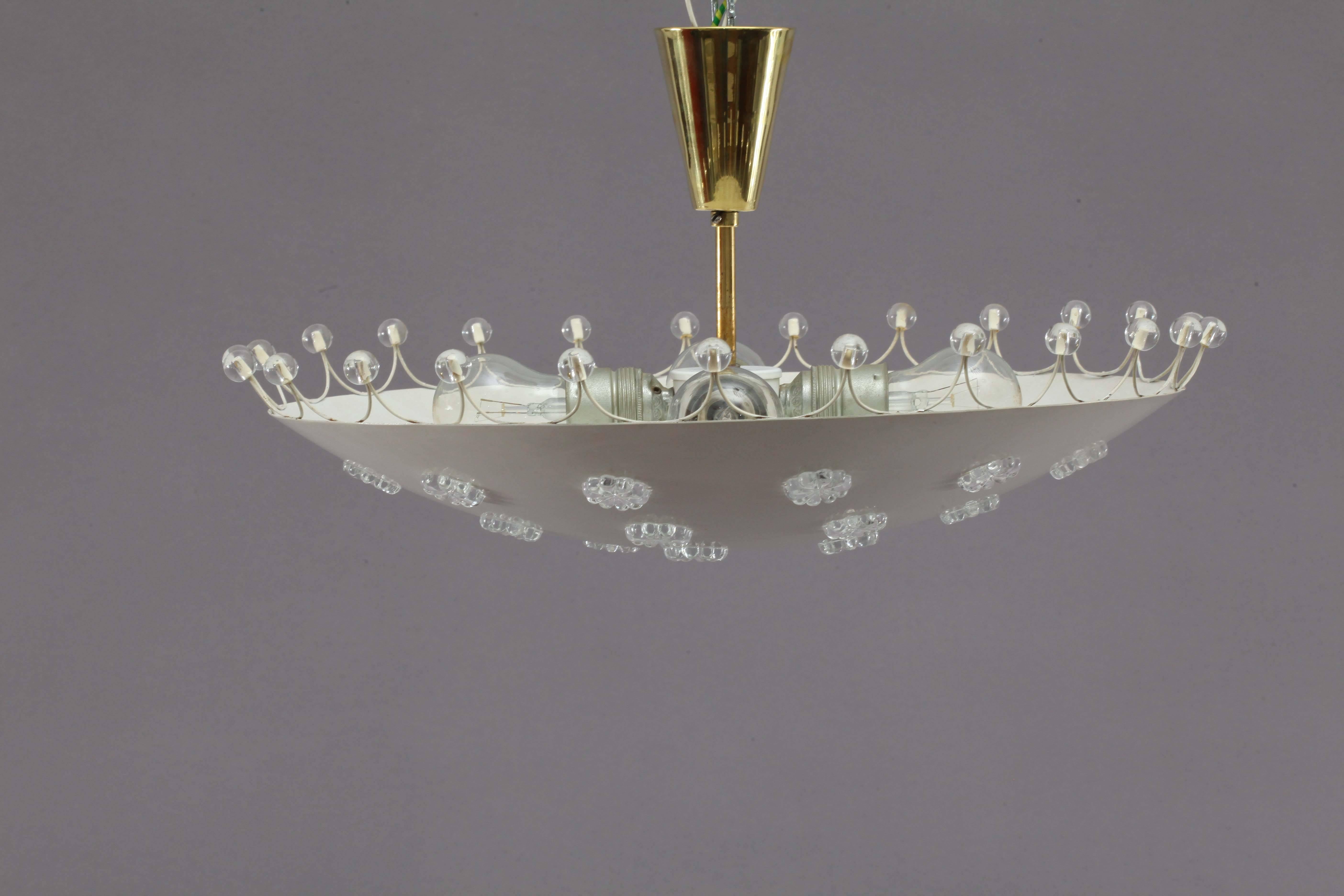 Ceiling flush mount,
Rupert Nikoll,
Vienna, 1950.
Laquered metal shade, crystal glass flowers and balls, brass conopy
four bulb sockets E 27 each max. 60 watt.
The length of the stem can be altered to any size for free.