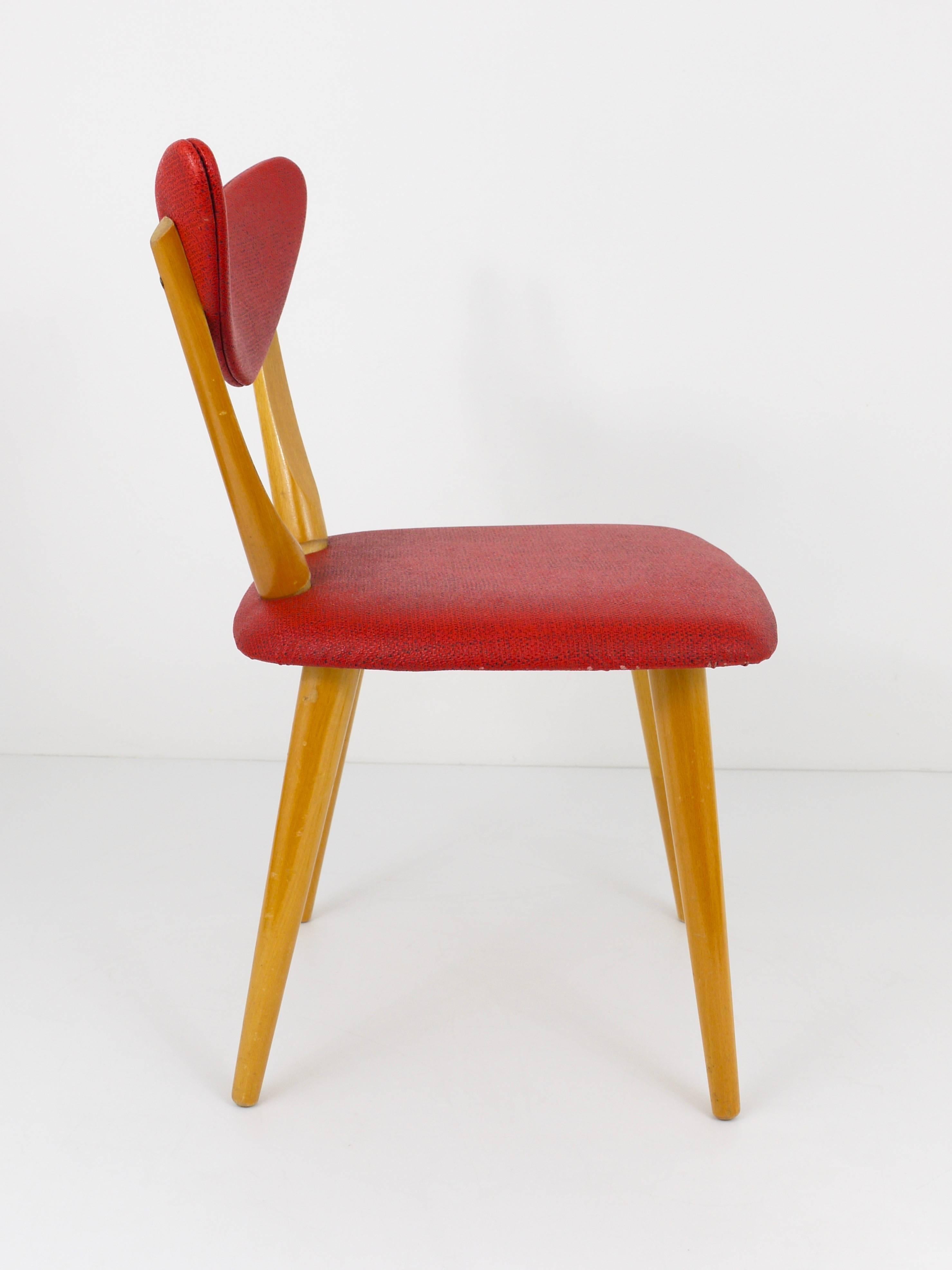 A beautiful modernist chair for children, made of wood with red synthetic leather upholstery and a charming heart-shaped backrest. Made in the 1950s in Austria.  In very good condition.

Measurements: total height: 23