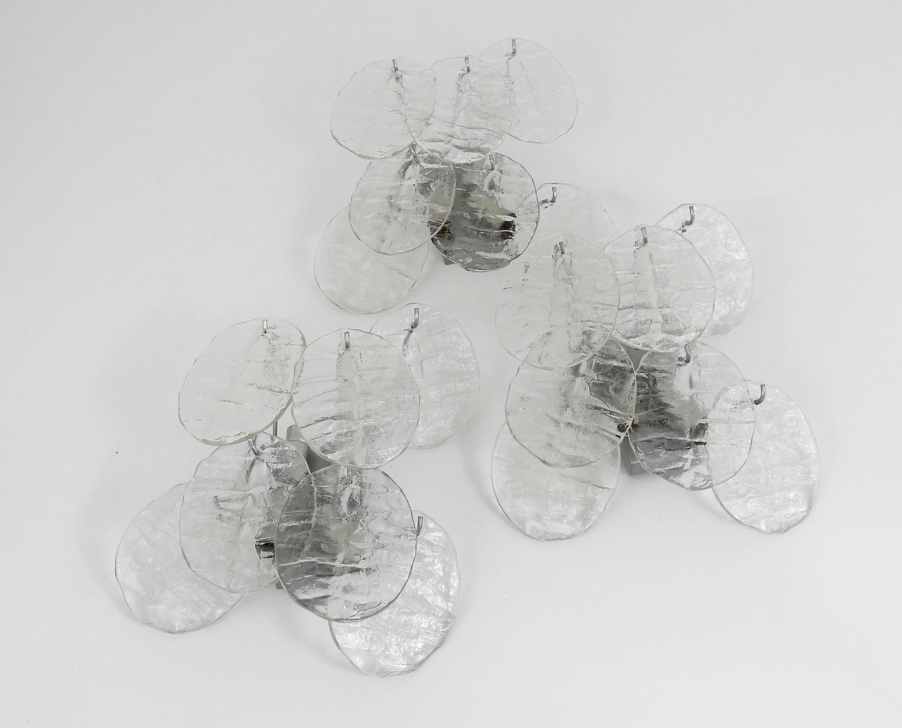 Up to three beautiful Austrian wall lights, executed by J.T. Kalmar Vienna in the 1960s. Sold and priced per piece. Seven leaf-shaped ice glass discs on a silver painted base with four light sources. In very good condition. 
Can be sold separately,