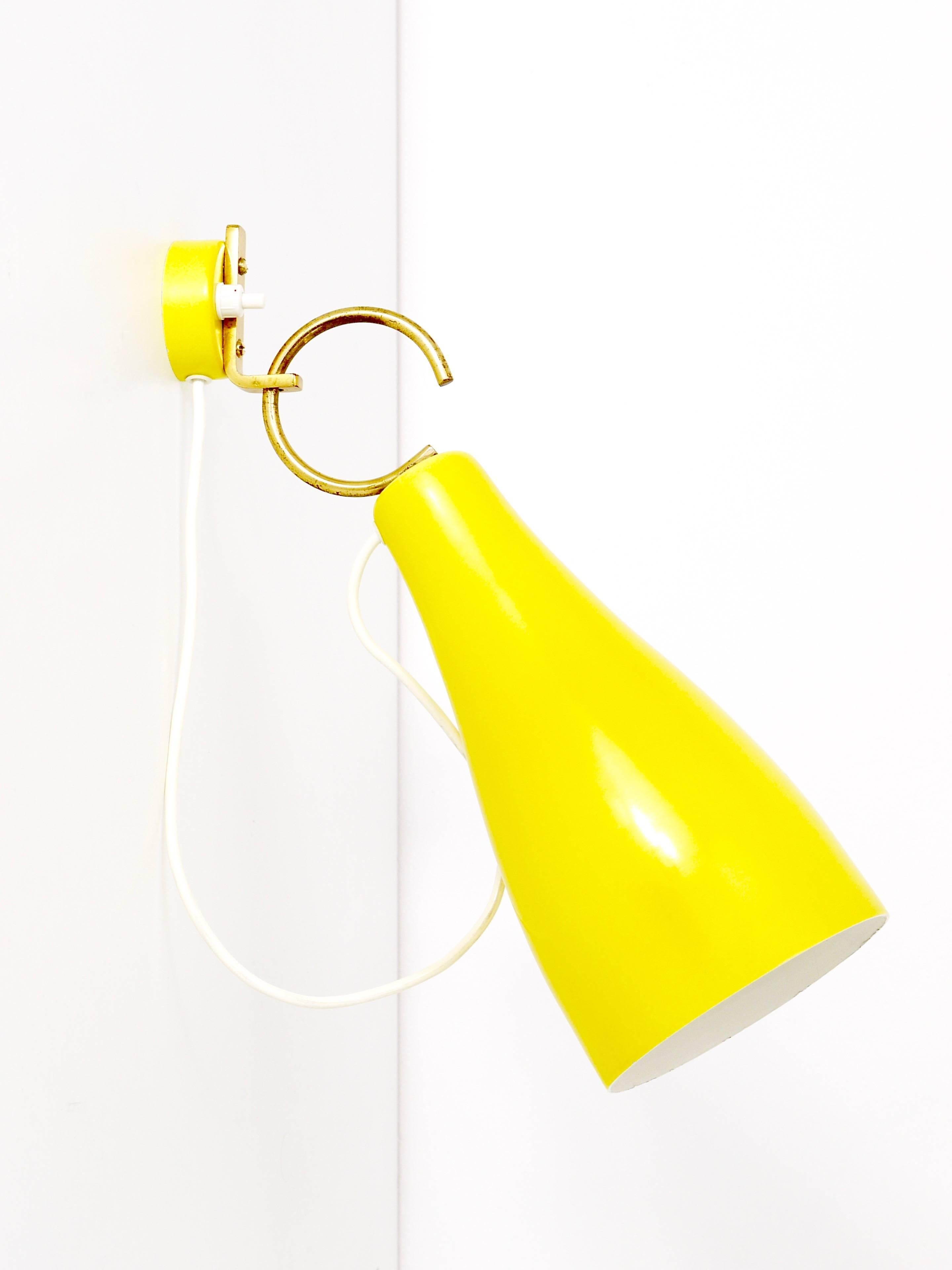 A pair of beautiful yellow wall lights from the 1950s, manufactured by J.T:. Kalmar Vienna, Austria. The lampshades are mounted on a round hook and adjustable in angle. Impressive and rare Austrian lights in very good condition with marginal patina