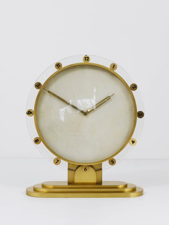 An impressive brass and glass desk or table clock with mechanical eight-day movement and a nice parchment clocks face. Made in Germany in the 1950s. An elegant and solid piece in good condition with little patina. Fully working. 

