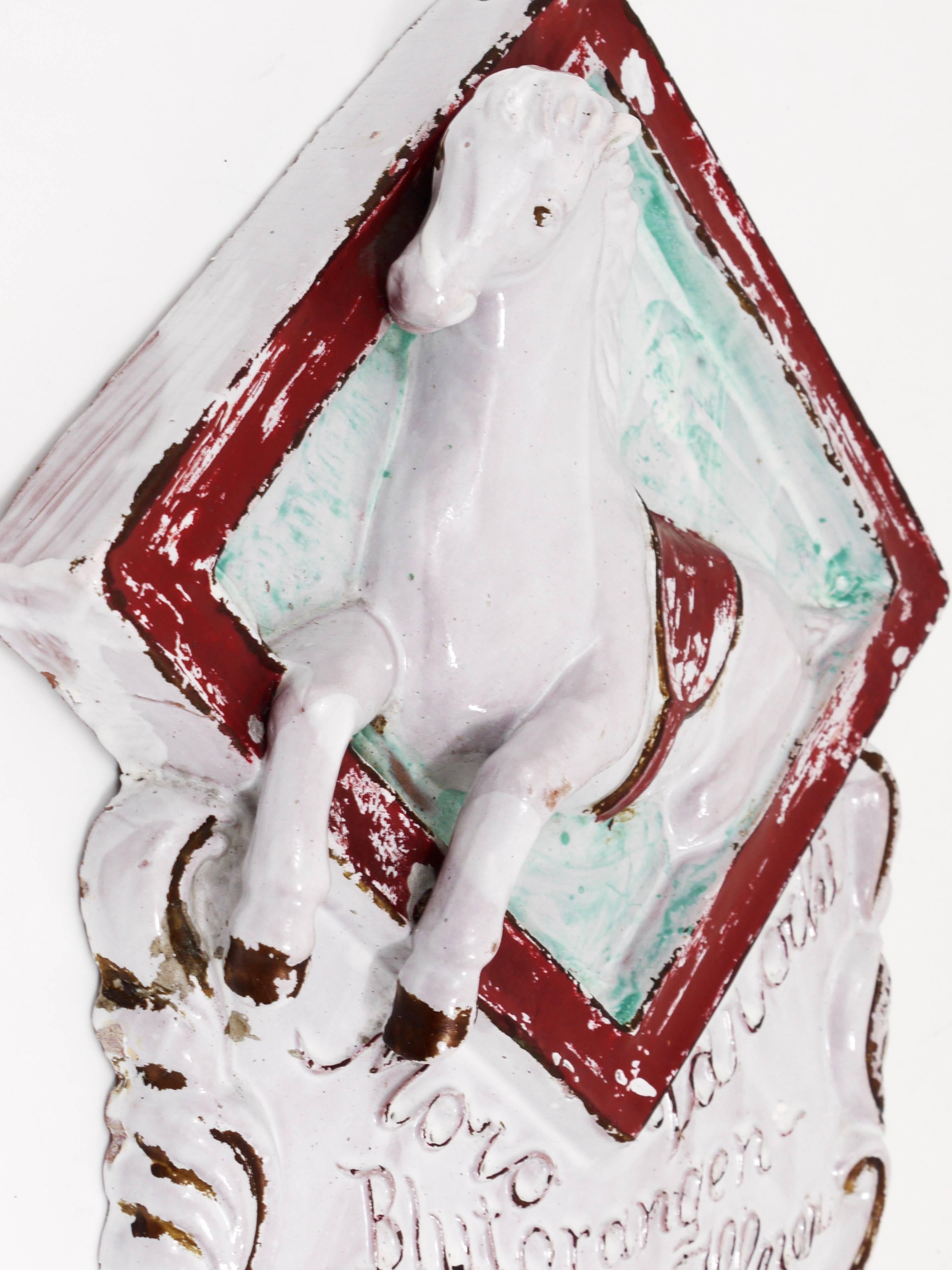 Ein dekoratives Werbeschild aus Keramik, datiert um 1920, hergestellt in Italien. Ein Werbeschild für den Verkauf von italienischen Blutorangen, auf dem ein weißes Pferd abgebildet ist. Guter Zustand mit charmanten Altersspuren.