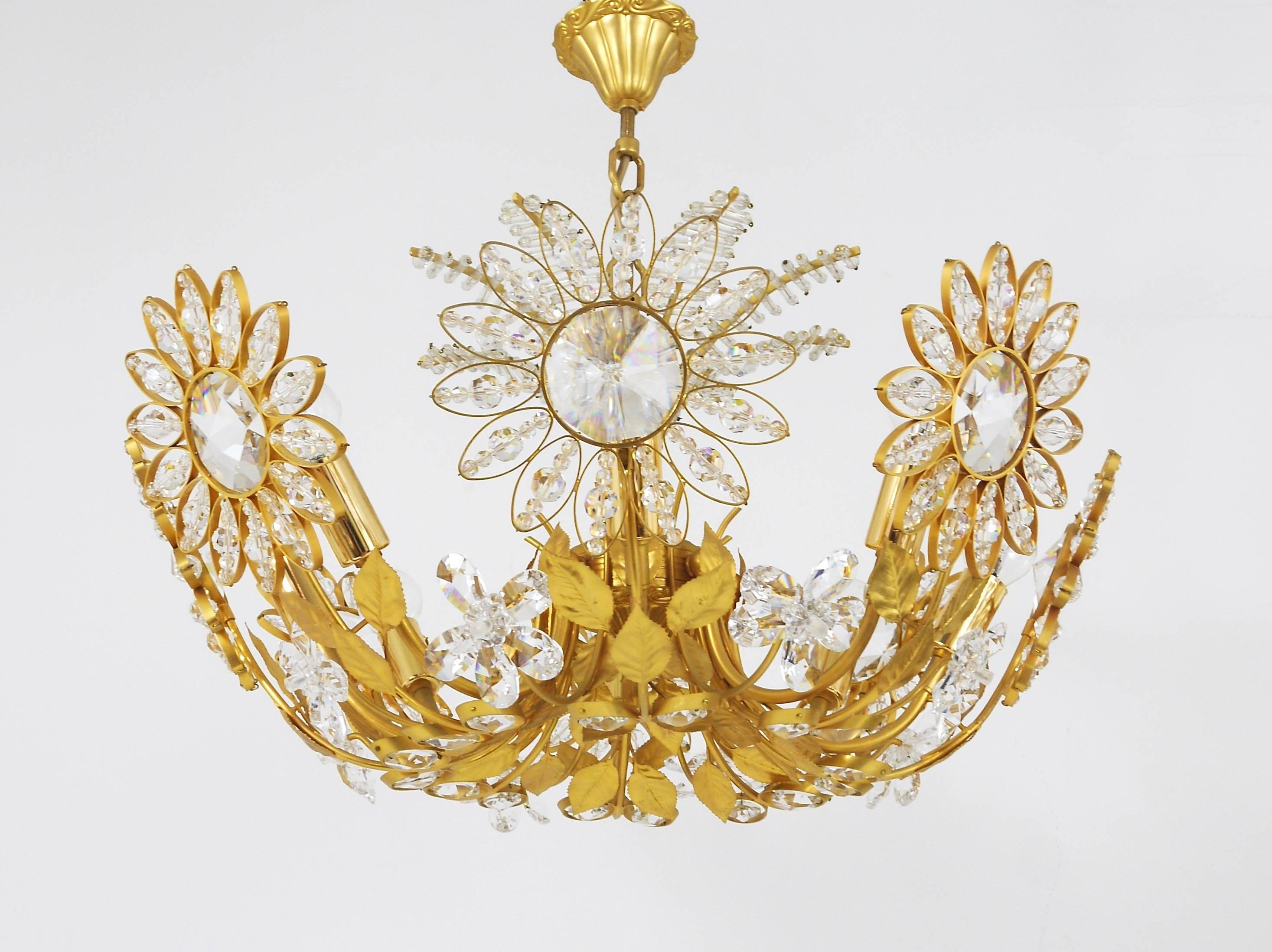 A beautiful hand-crafted floral chandelier with a decorative palm tree top from the 1970s by Ernst Palme, manufactured by Palwa (Palme & Walter), Germany. Made of gold-plated brass with big faceted crystal glass petals. Has eight-light-sources. In