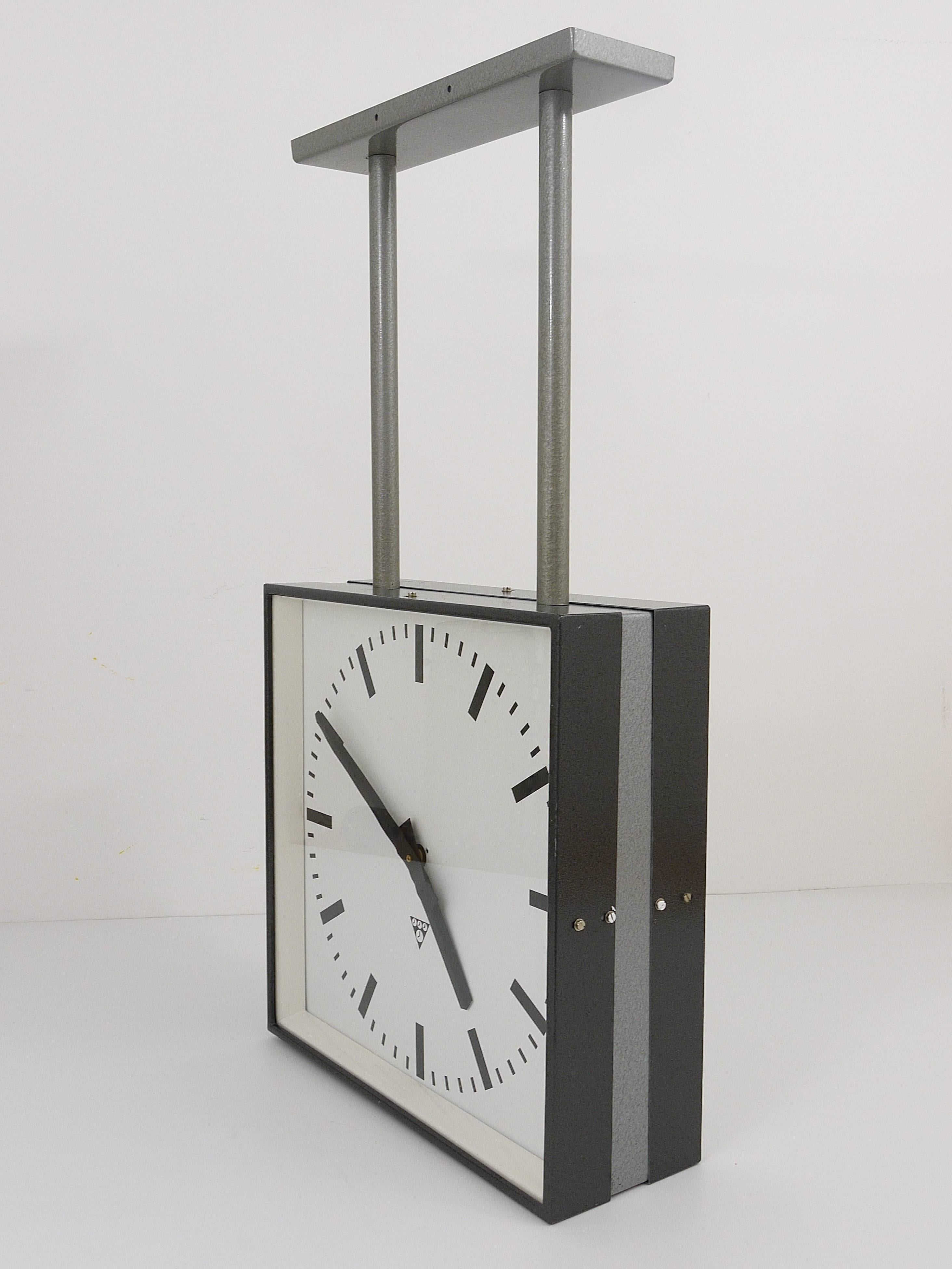 A very big loft Industrial clock from the 1950s, to mount on the ceiling or on the wall. Very straight but beautiful design, this is a double sided clock with two clock faces. The housing is made of grey painted metal. Powered by two quartz