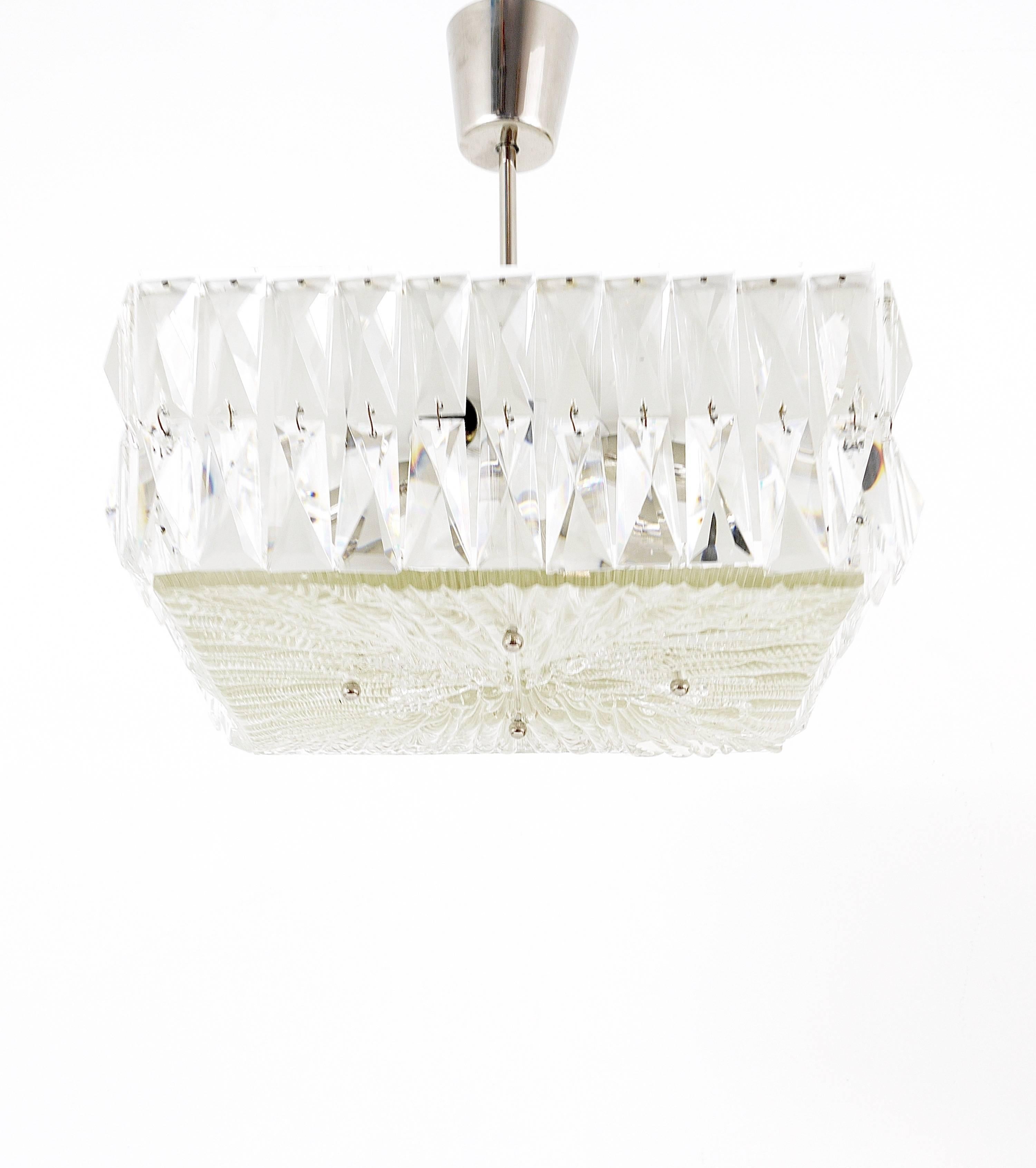 Lampe suspendue carrée du milieu du siècle dernier des années 1960, fabriquée à la main par Bakalowits Vienna en Autriche. Une belle pièce, une quincaillerie en métal blanc et nickelé entourée de deux rangées de cristaux carrés à facettes. L'ajout