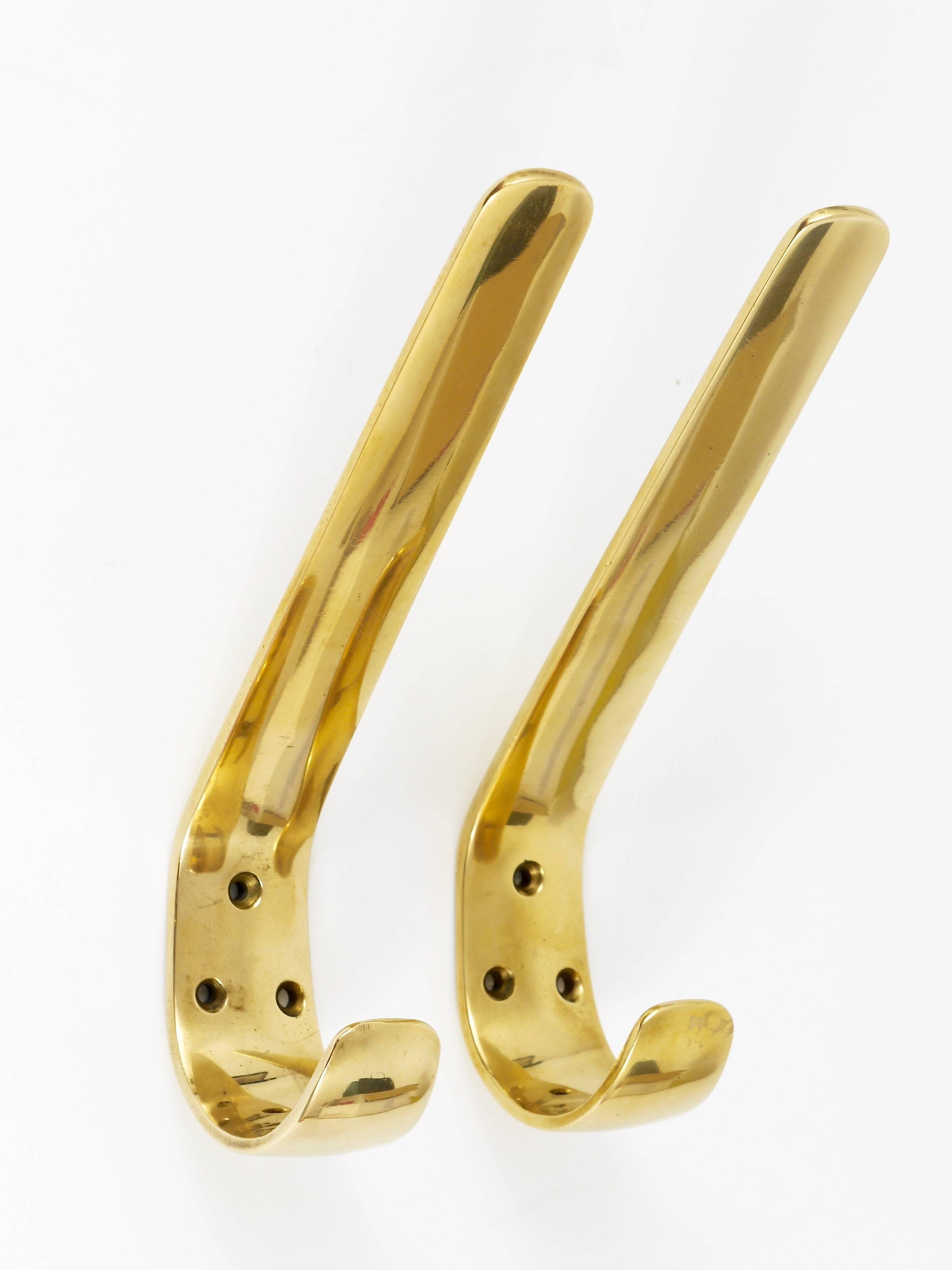 A pair of beautiful Austrian modernist brass wall hooks, very solid, executed in the 1950s by Hertha Baller, Austria. Gently polished by hand in very good condition with nice patina.