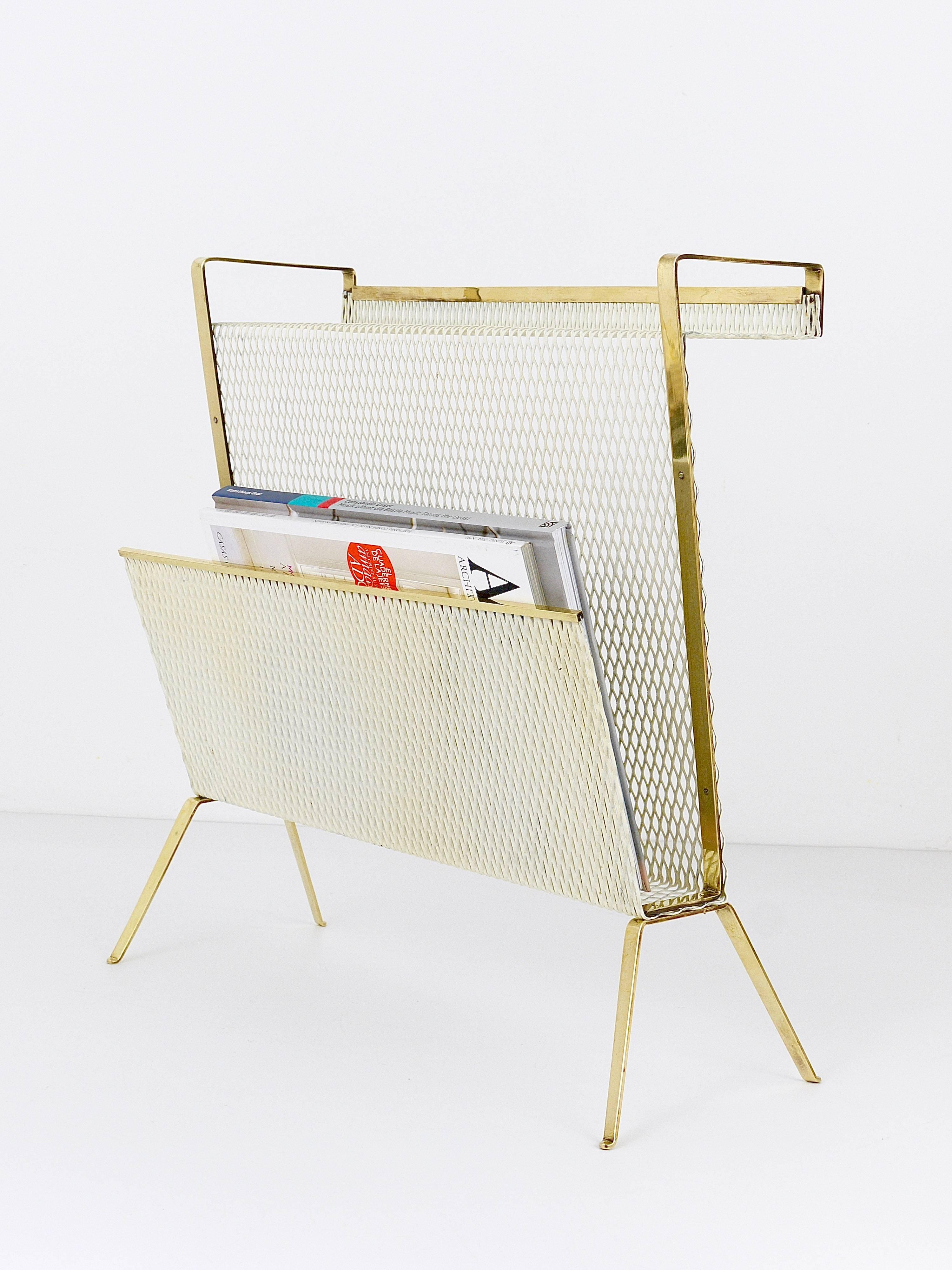An beautiful asymmetrical modernist magazine holder news stand with brass frame and white perforated metal in the style of Mathieu Mategot. From the 1950s, made in France. A unusual piece in good condition with nice patina.
