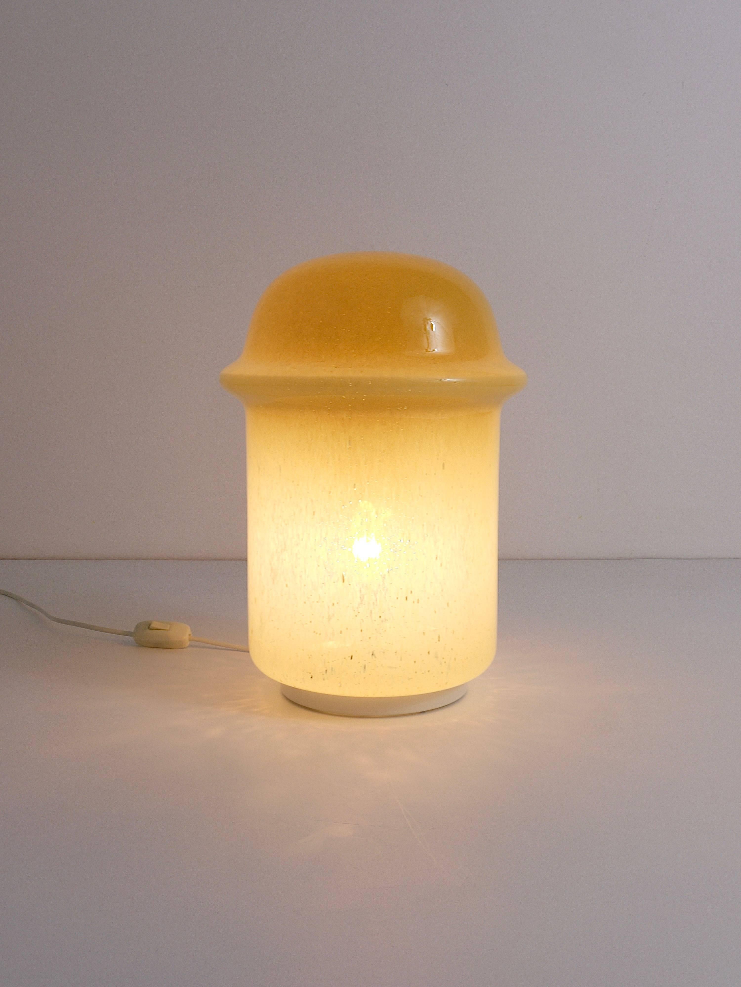 A wonderful modernist mushroom table or side lamp, featuring a handblown art glass lampshade in beige / amber, adorned with nice bubbles within the glass. Crafted in the 1960s, this lamp is in very good condition and evokes the style of Carlo Nason