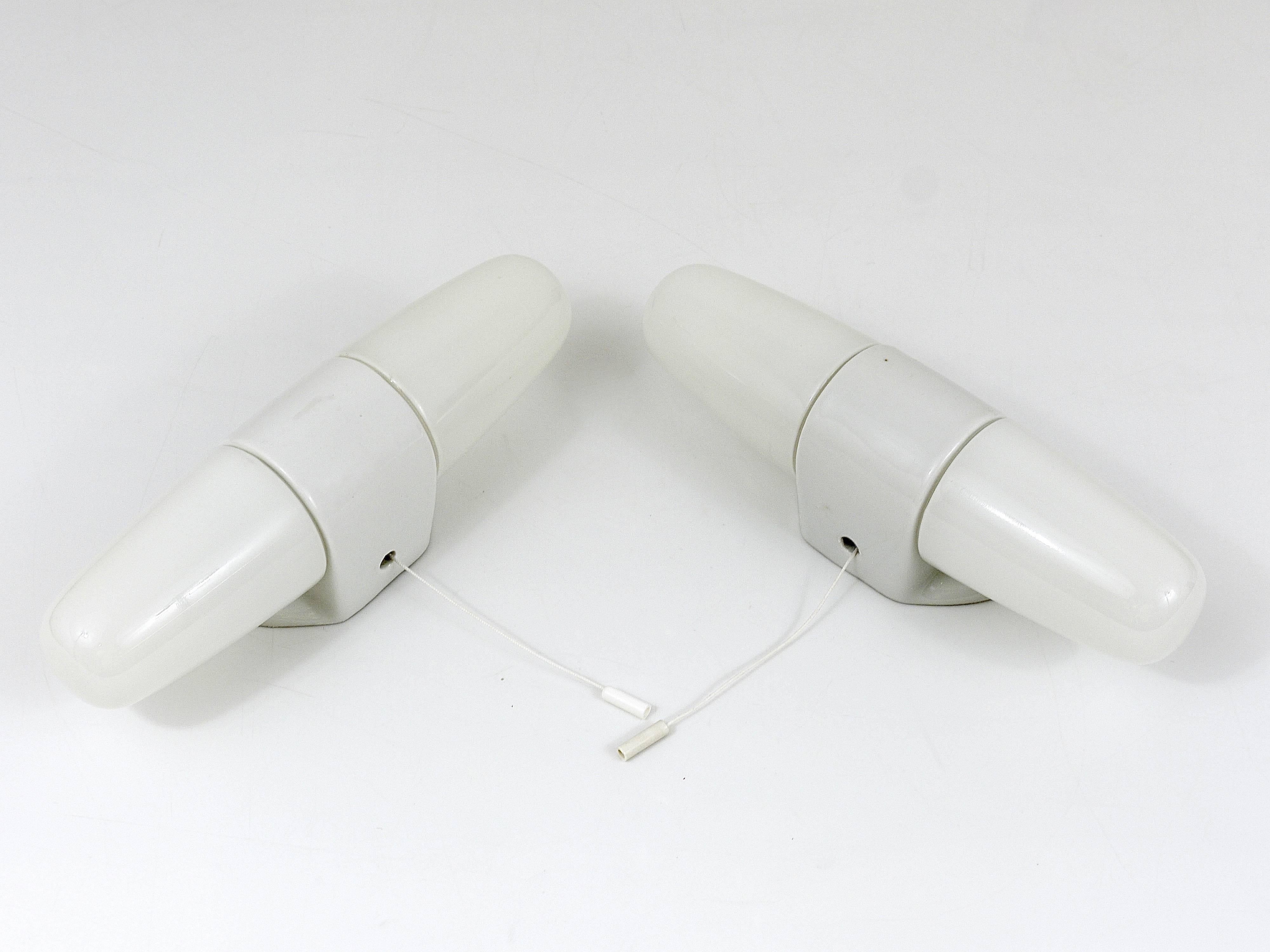 Two beautiful wall lights with two sockets each, made of porcelain with white glace and opal glass bulb covers, designed by Wilhelm Wagenfeld. Executed in the 1950s by Linder Wandleuchten, Germany. Has integrated switches, which can be removed