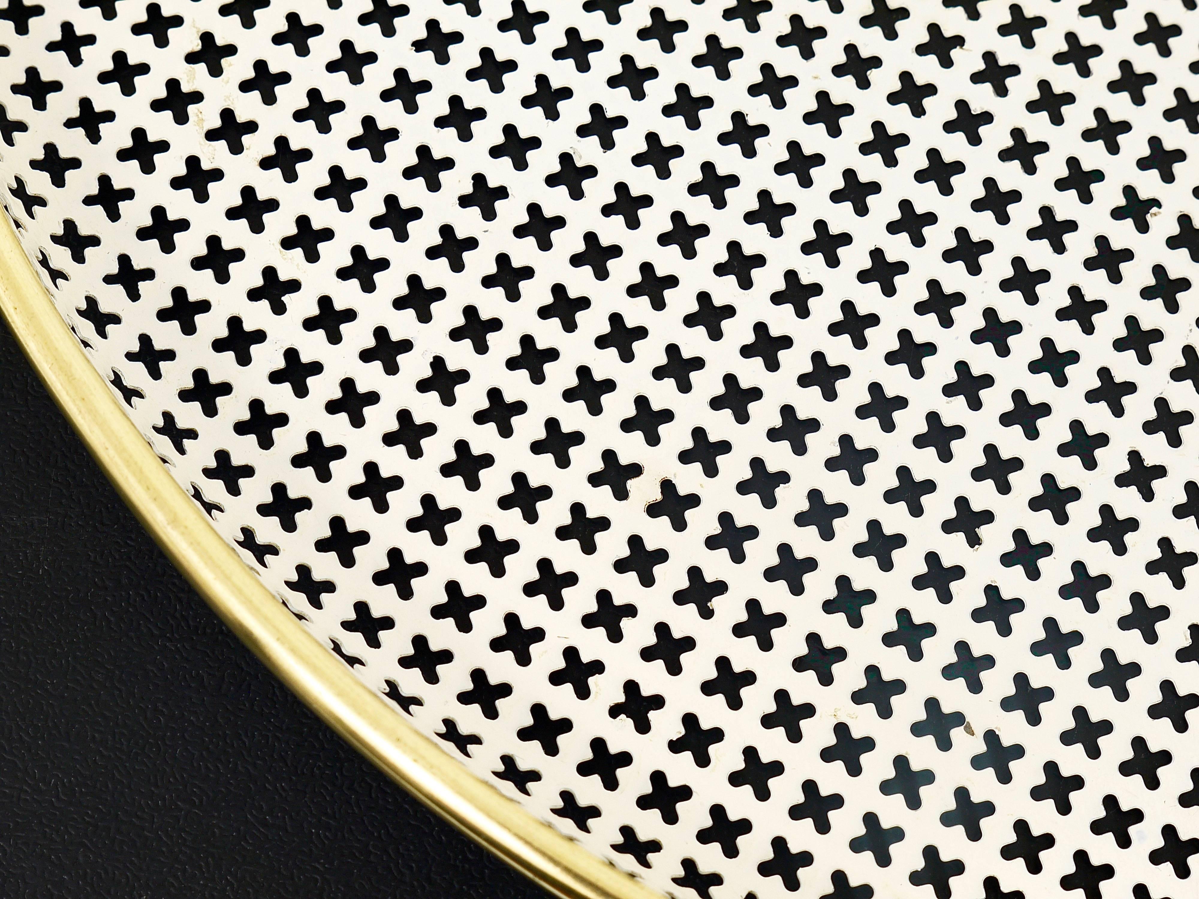 A round modernist serving tray, made of white perforated metal with a brass frame. Manufactured in the 1950s by Muenchner Werkstaetten, Germany. In excellent condition.