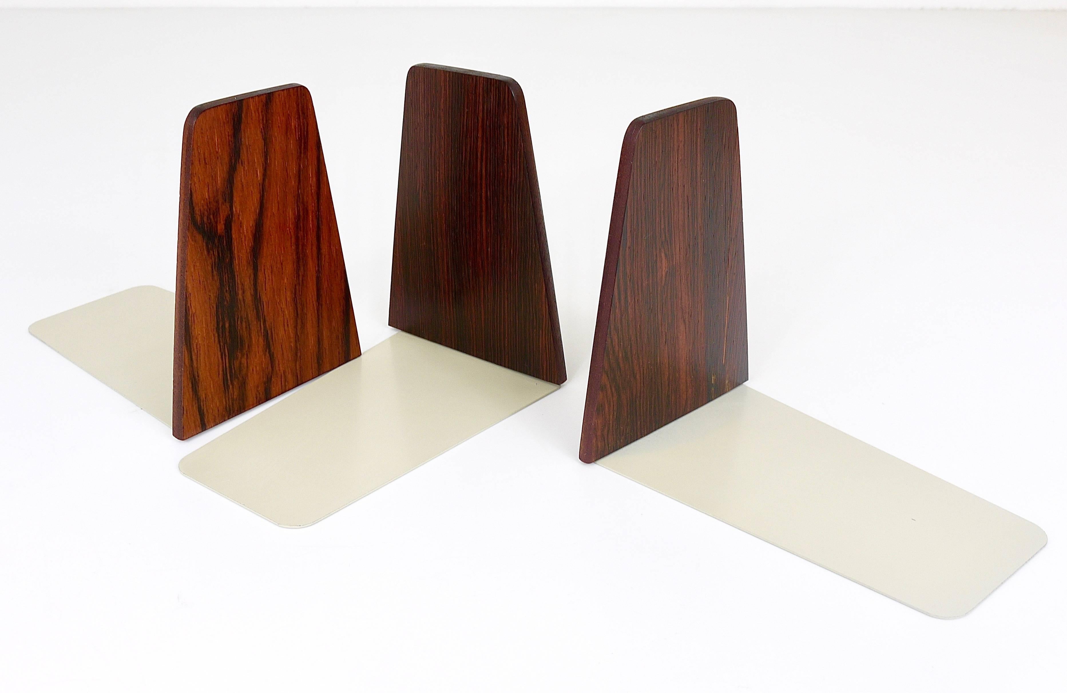 A set of three beautiful mid-century bookends, made of rosewood with grey lacquered metal bases in very good condition. We offer another set of two nearly identical book ends in our other listings.