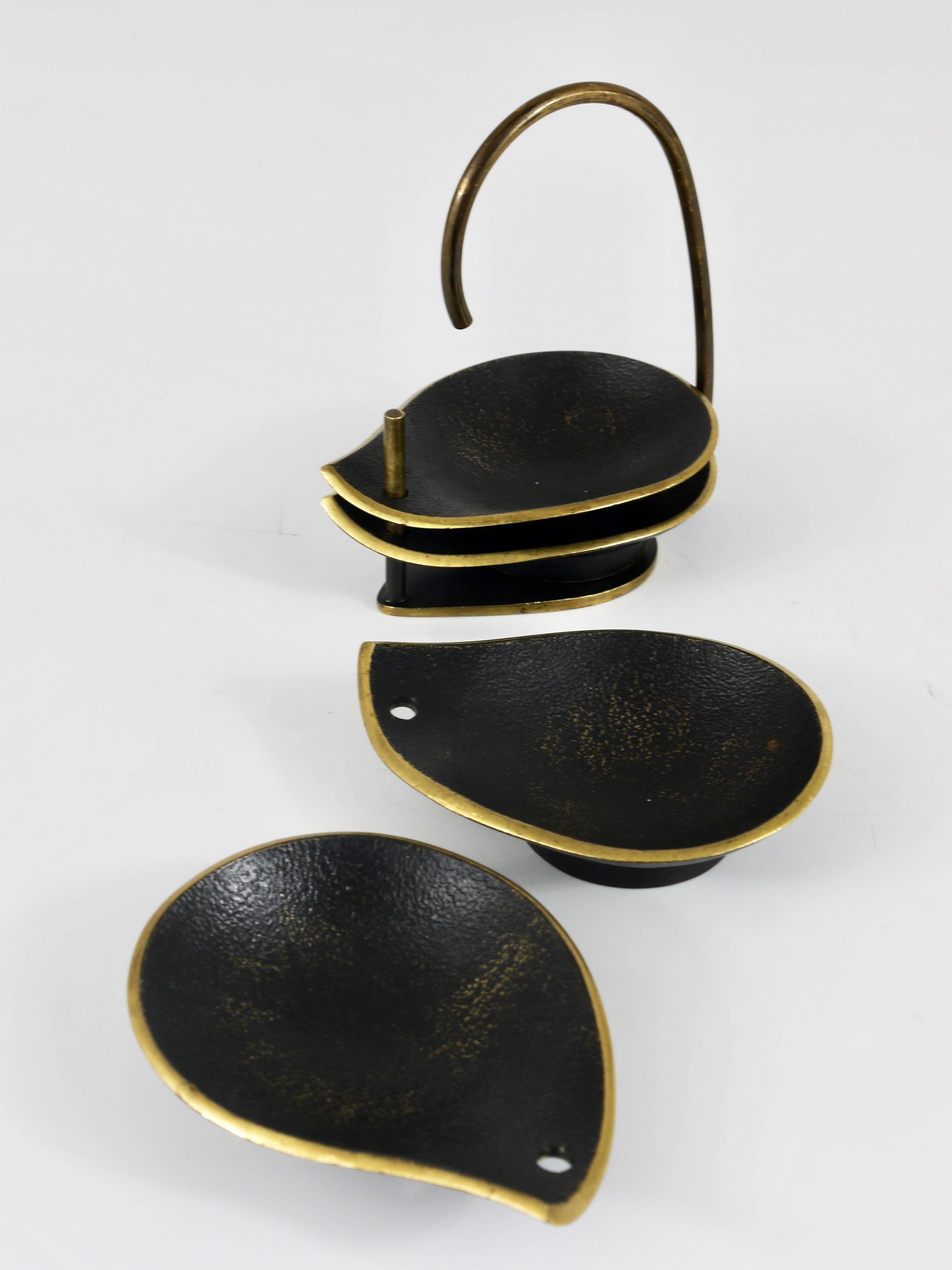 A charming set of four beautiful black-finished modernist brass ashtrays in the shape of drops, with stand from the 1950s. Made in Austria by Richard Rohac. In good condition with nice patina.