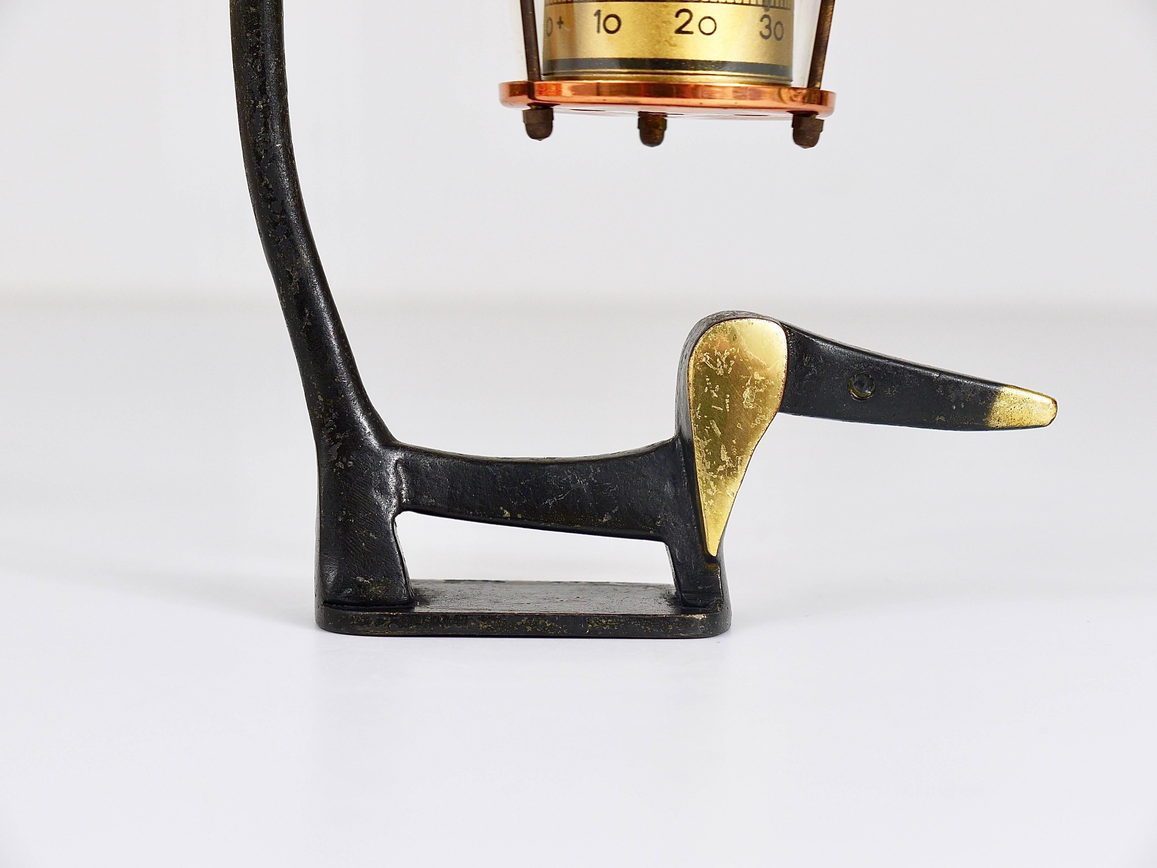 A very charming Austrian Mid-Century desk thermometer, consisting of a nice wiener dog / sausage dog figurine made of brass and a lantern-shaped thermometer. A very humorous design by Walter Bosse, executed by Herta Baller Austria in the 1950s. Made