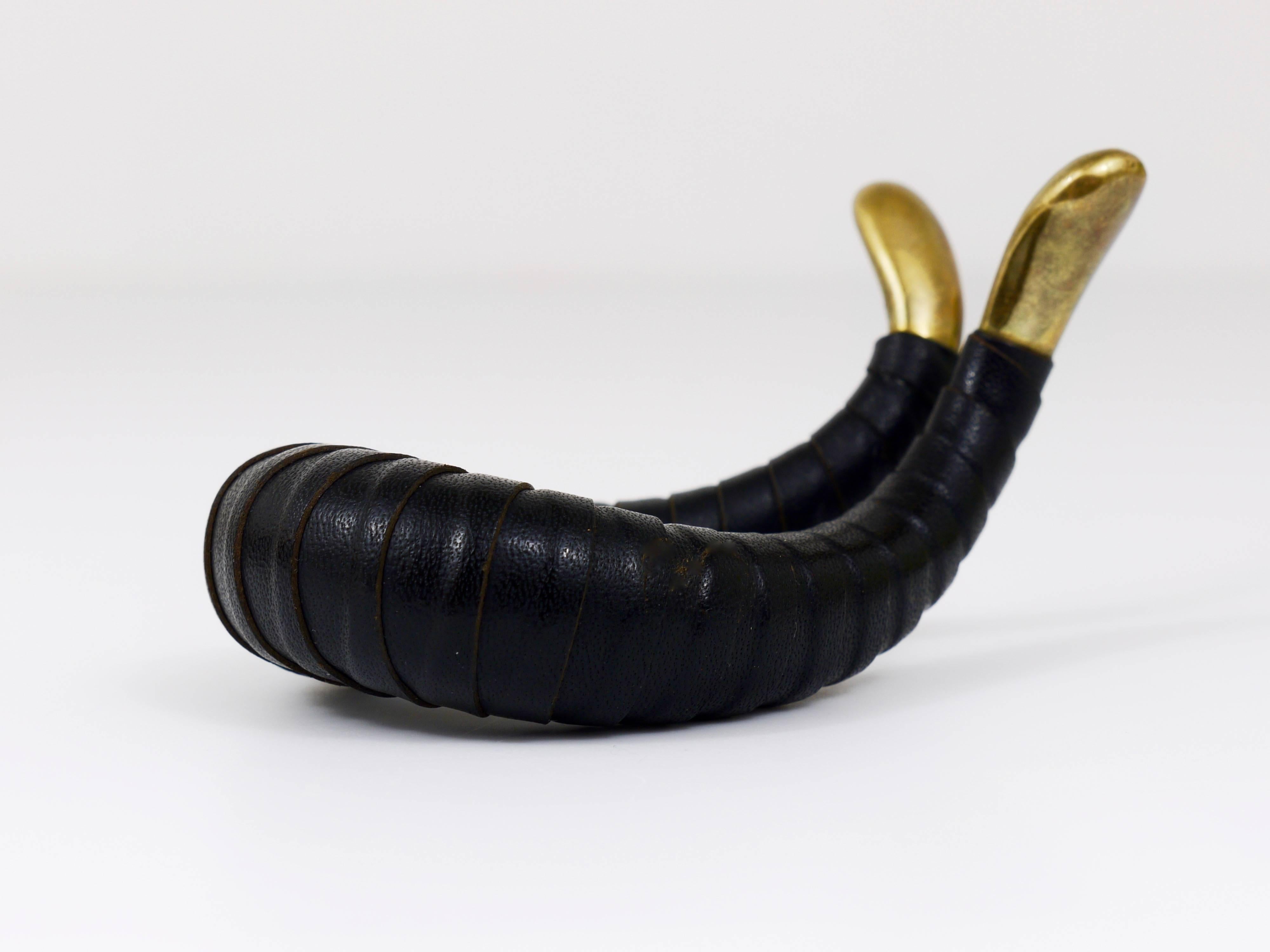 A beautiful vintage modernist pipe stand, made of solid brass and black leather. Designed and executed in the 1950s by Carl Aubock, Vienna. This pipe rest is in very good condition.