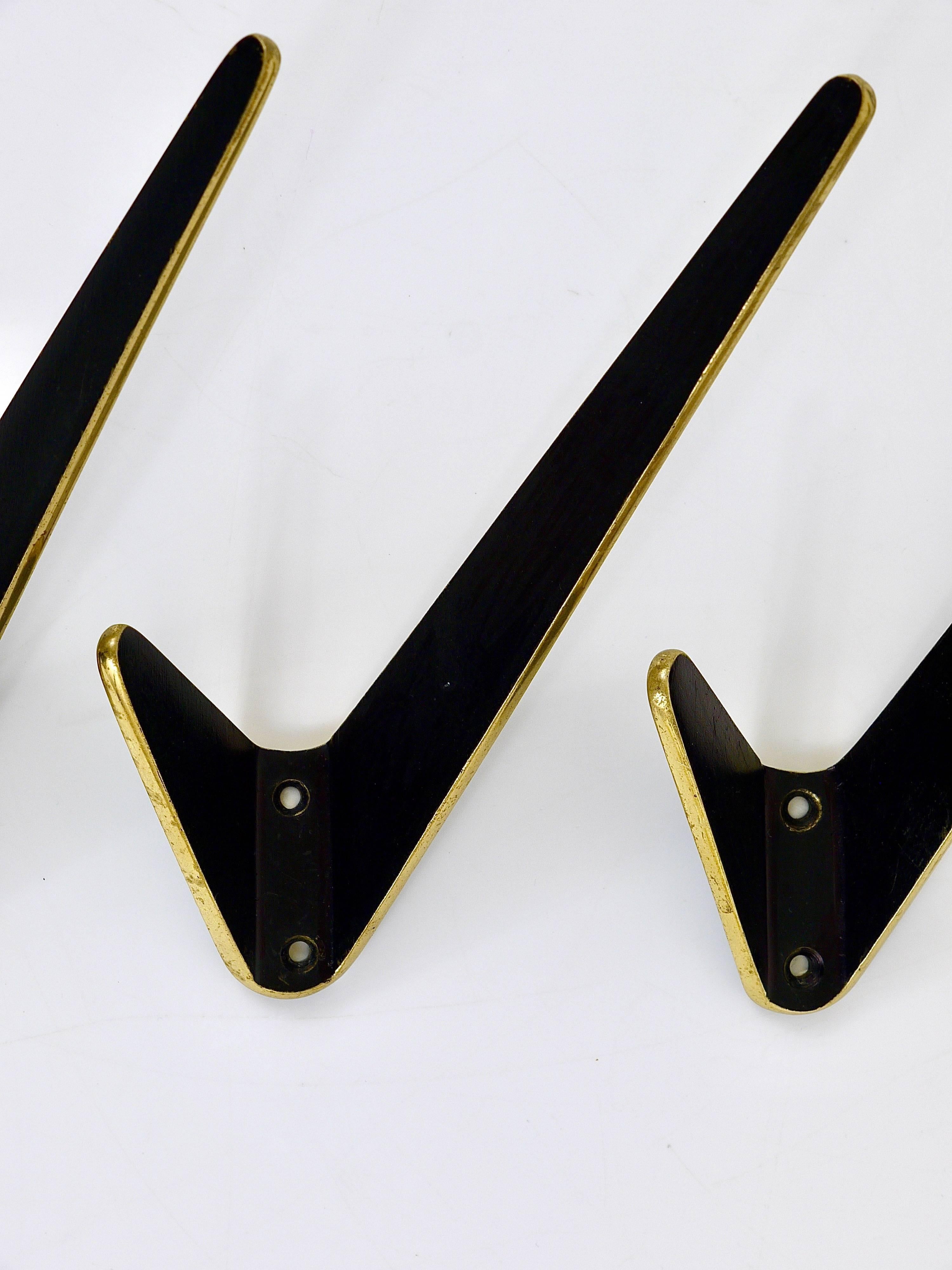 Up to eight beautiful asymmetrical Austrian modernist brass wall coat hooks, crafted in the 1950s. Made of black finished and partly polished brass. Good condition, nice patina. Sold and priced per piece.