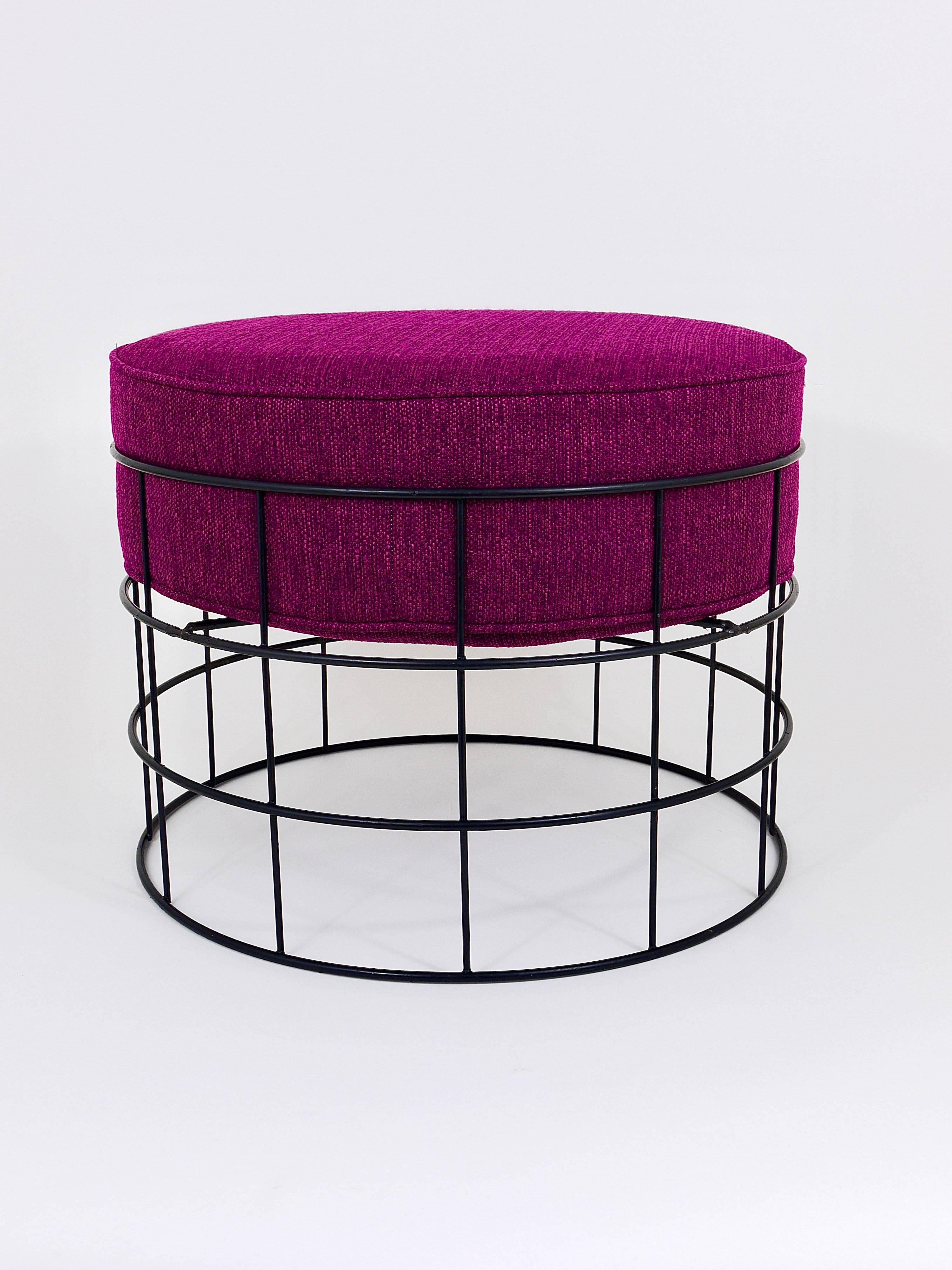 A beautiful round wire stool from the 1960s, designed by Verner Panton for Studio Linje, Denmark. It features a wire frame base made from black-coated metal as well as a newly upholstered seat pad in purple/pink/violett. The stool is in very good