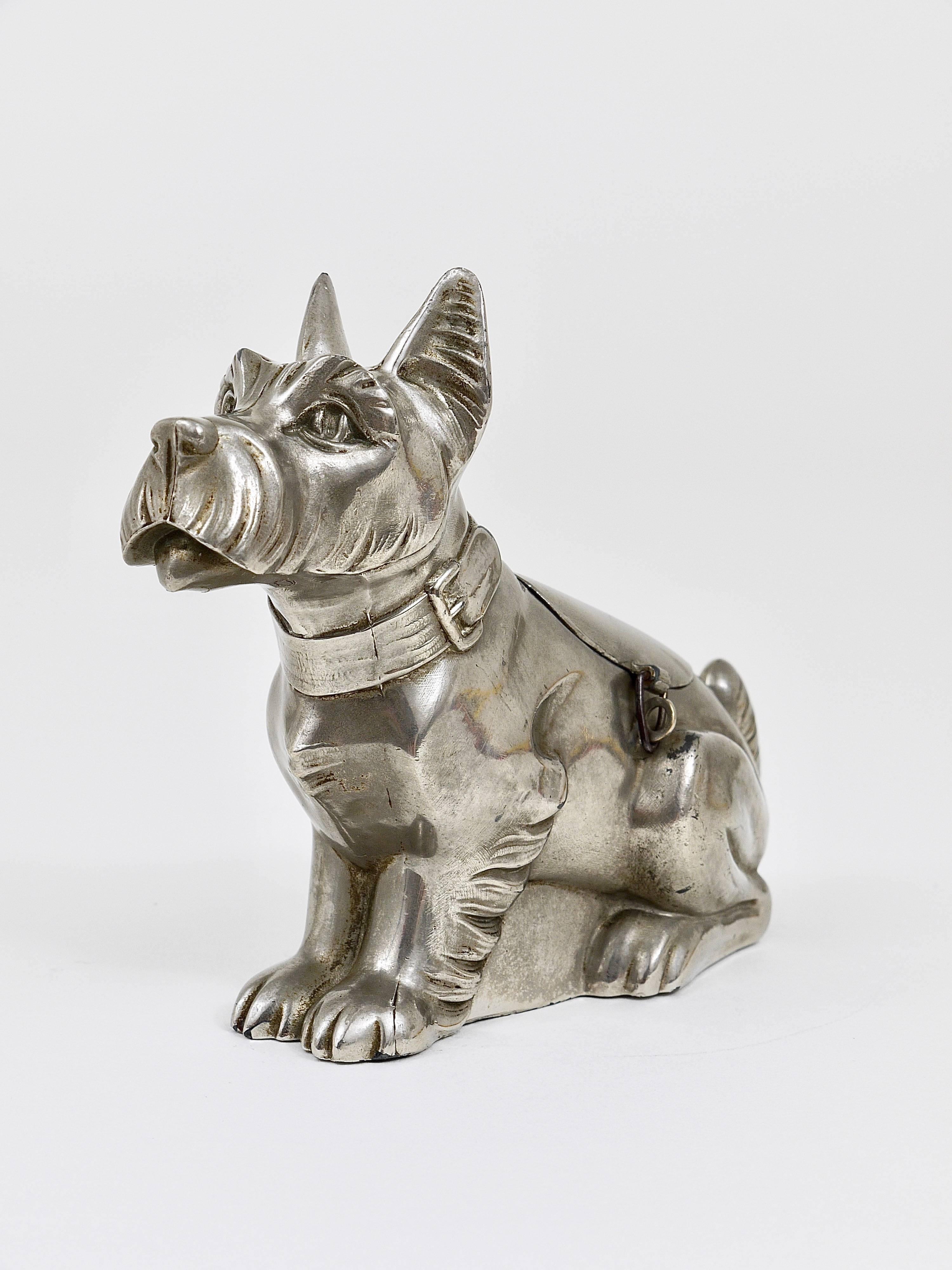 An unusual Art Deco piggy bank /savings box displaying a Schauzer dog. Made of tin in the 1930s in France. A beautiful piece.
       