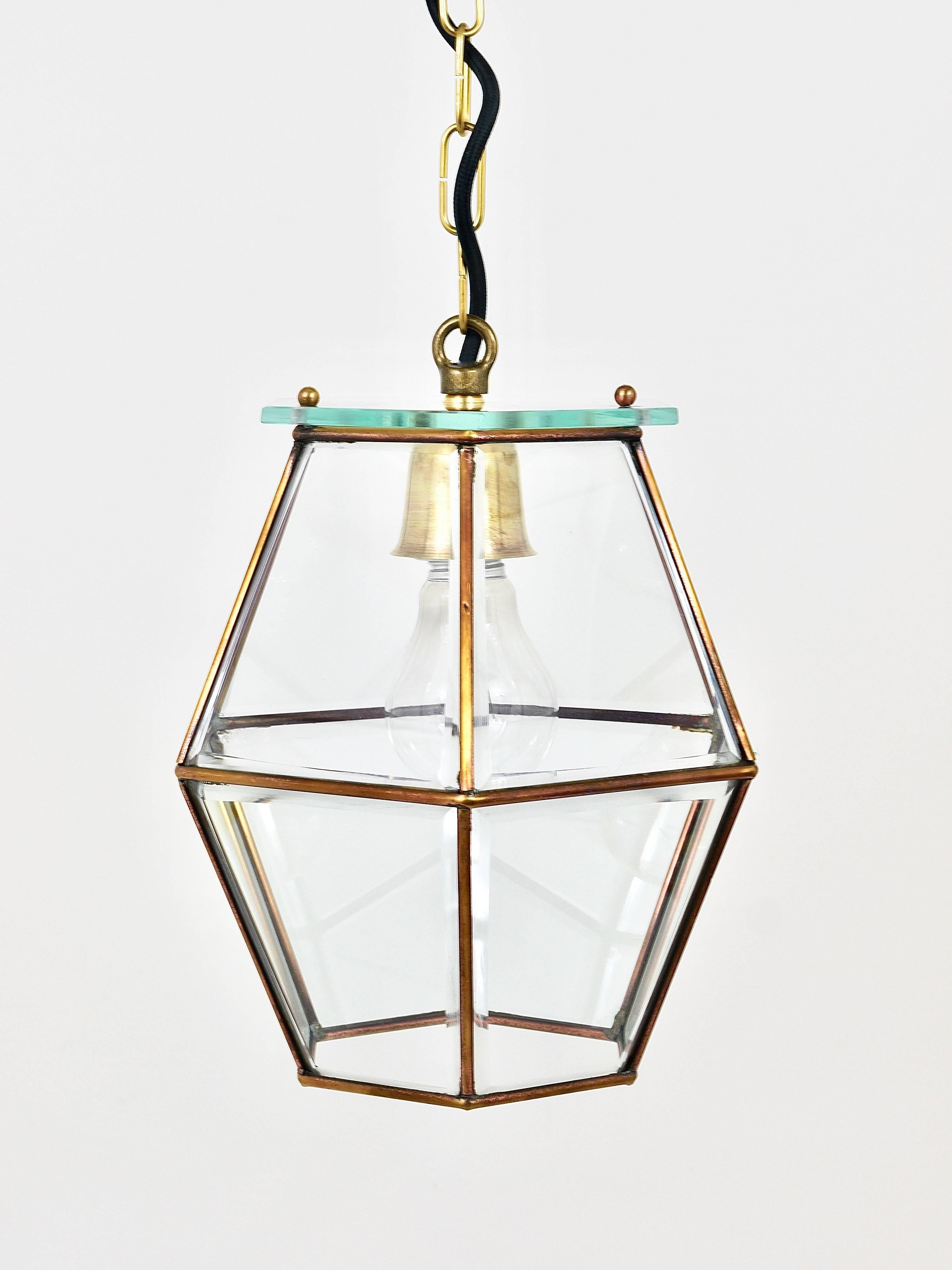 A beautiful Italian brass lantern or pendant light, dated circa 1940s, in the style of Fontana Arte. The lamp was handcrafted and is of high craftsmanship. The light features a hexagonal brass frame with faceted glass windows. The lamp has been