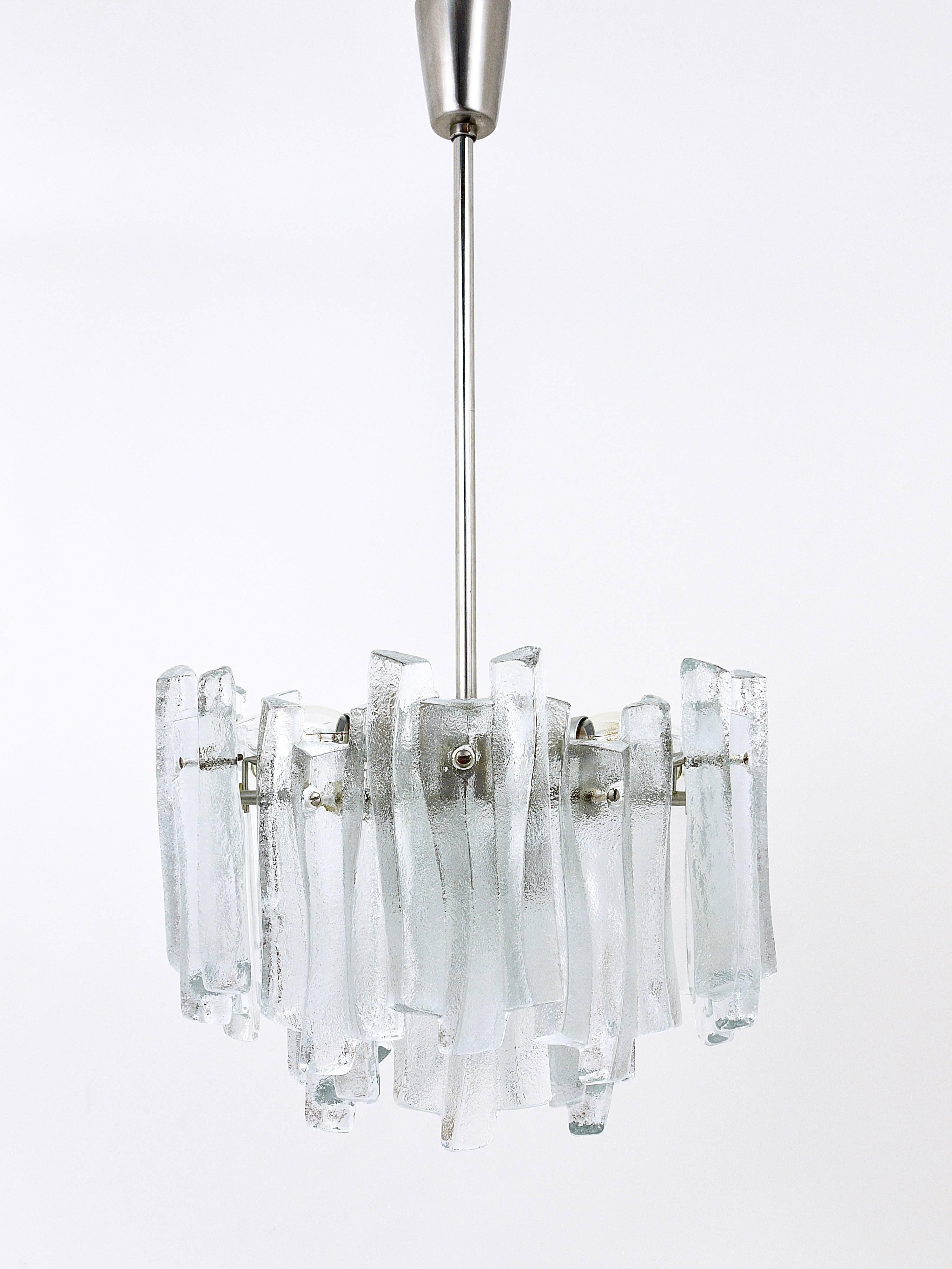 A beautiful modernist chandelier or pendant lamp manufactured by Kalmar Austria in the 1960s. This chandelier has two layers of textured solid ice glass sheets (18 pieces). In excellent condition. Seven-light sources. Makes a wonderful light.