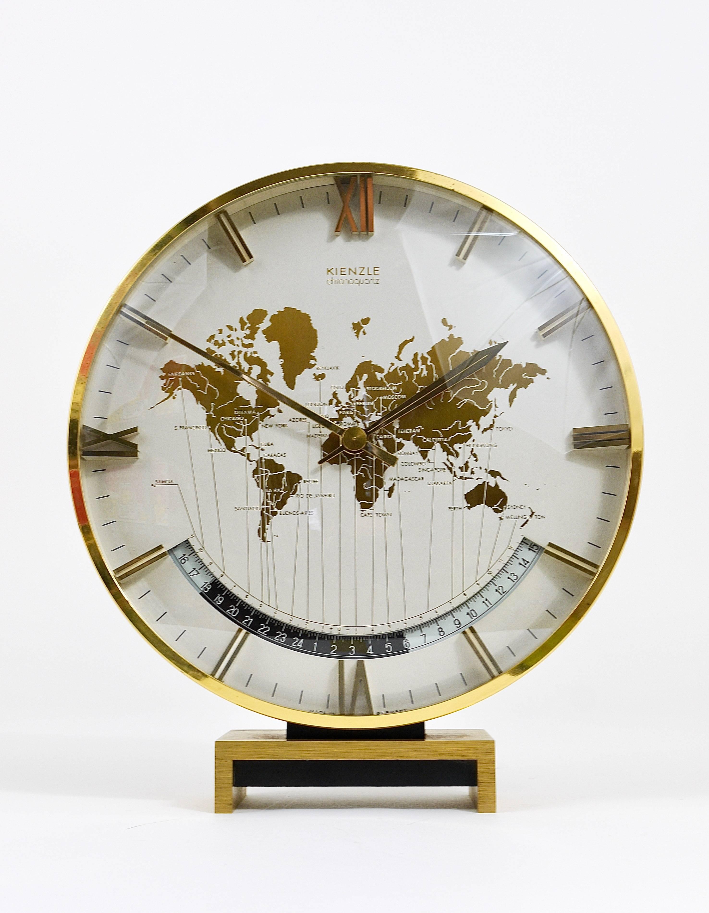 A impressive and large brass and glass modernist desk or table clock with a world map clocks face and world time zones and beautiful three-dimensional digits. Executed in the 1960s by Kienzle Germany. An elegant and solid piece in very good