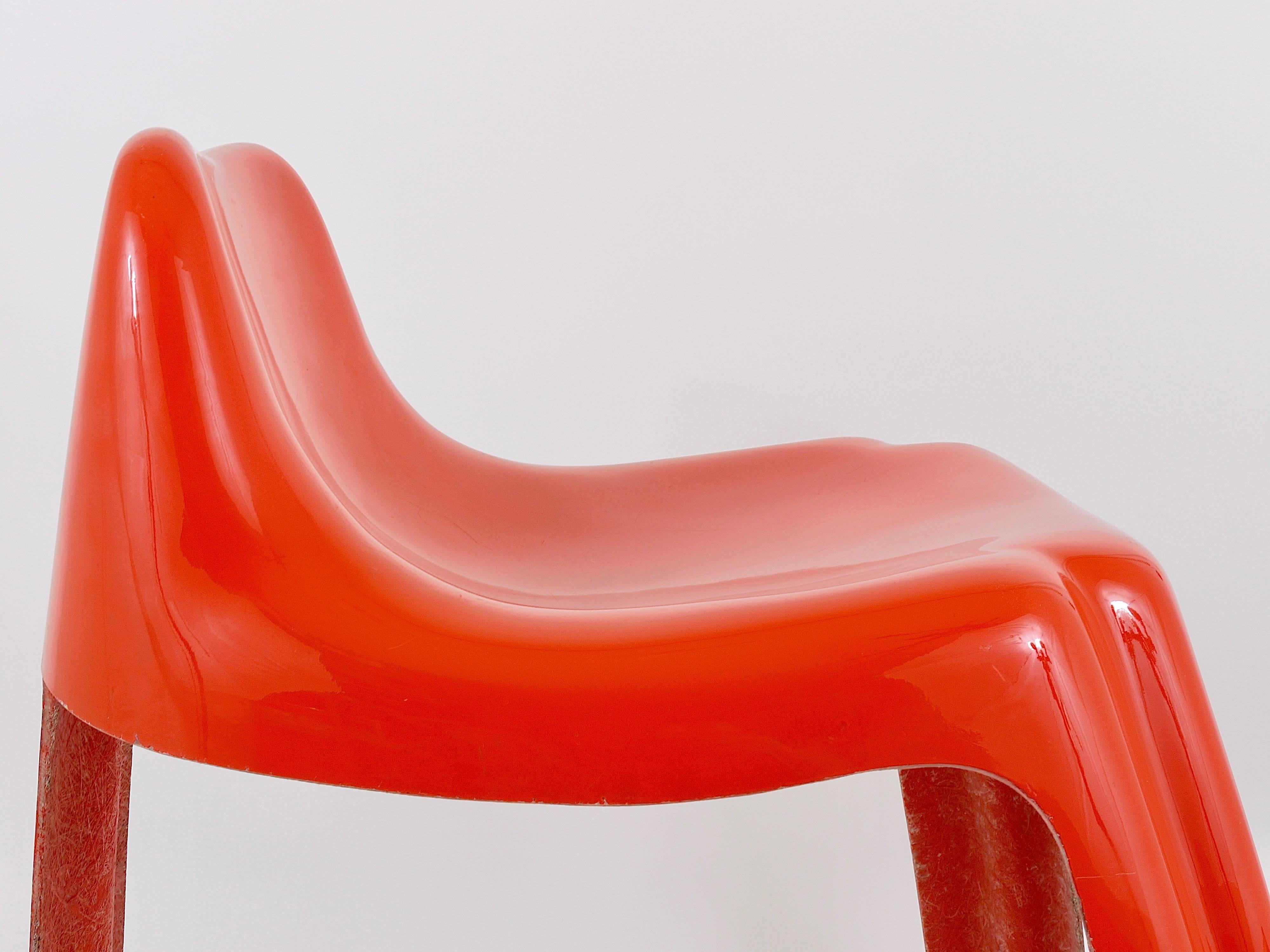 An orange midcentury stool or chair from the 1970s, crafted from lacquered fiberglass. This beuatiful piece, known as the 