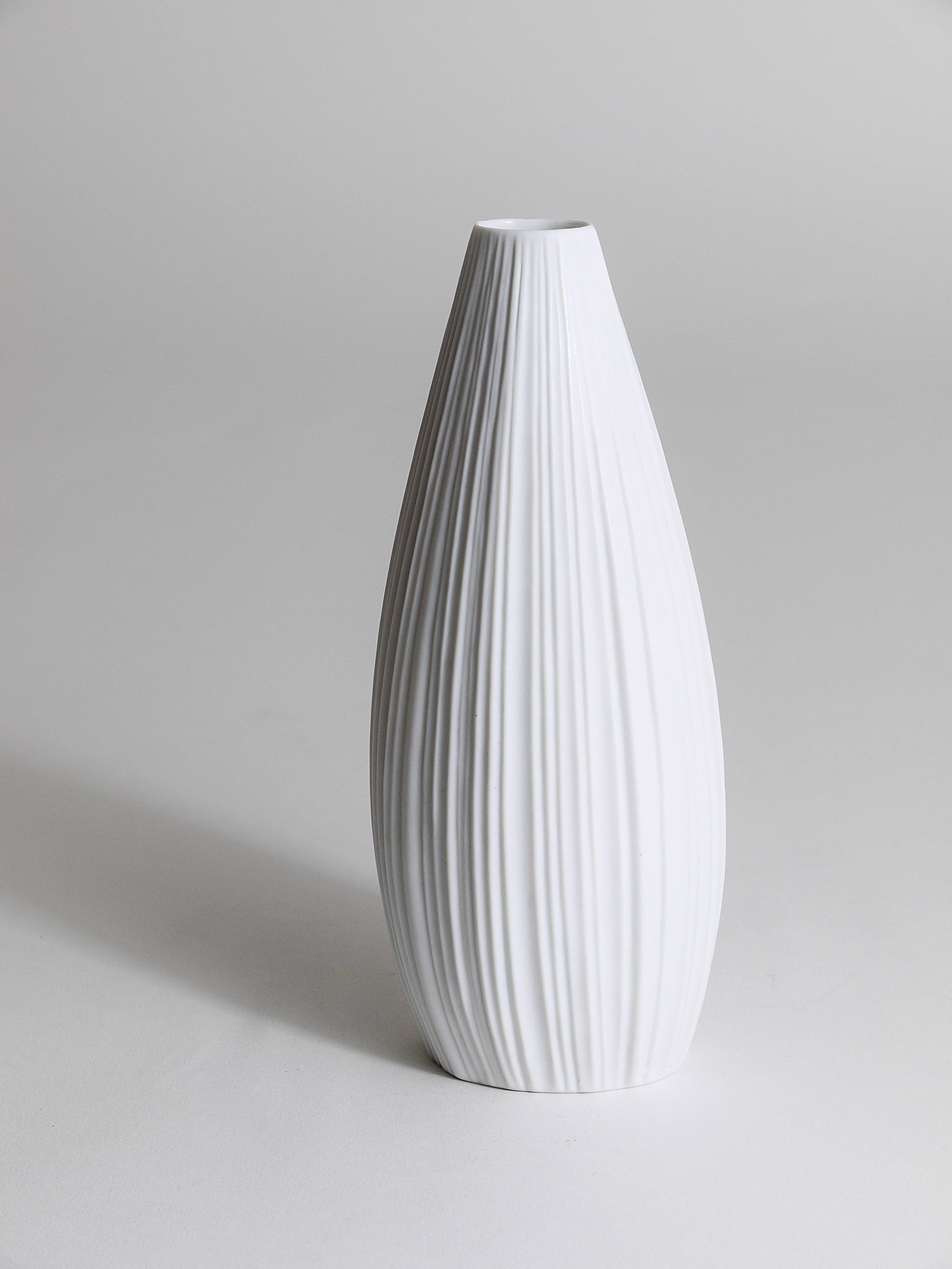 Un beau vase en porcelaine biscuit à relief rayé blanc mat des années 1960, conçu par Martin Freyer, exécuté par Rosenthal, Allemagne. En très bon état.