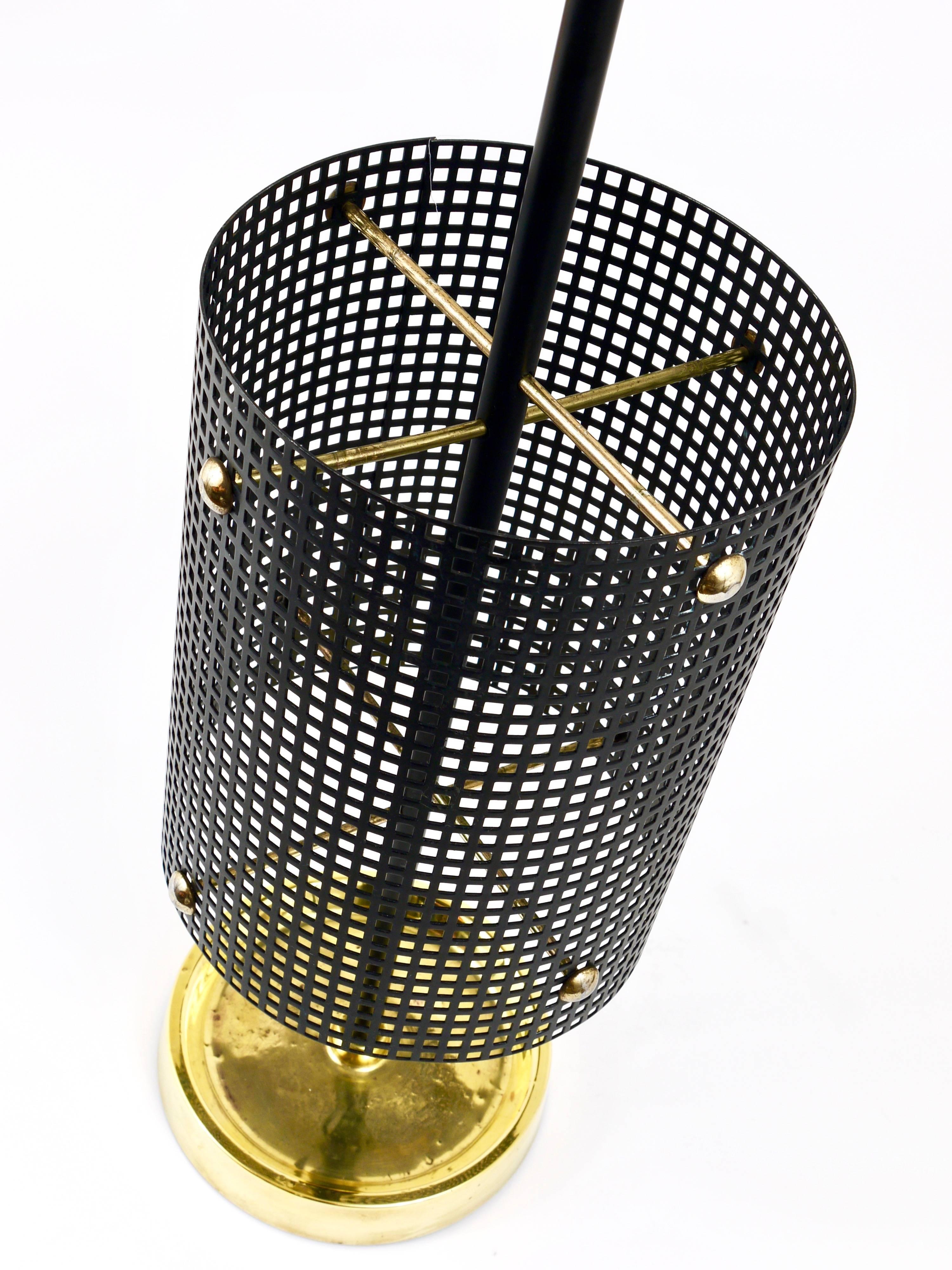 An beautiful modernist umbrella Stand from the 1950s in the style of Mathieu Mategot. Made of perforated metal and brass. A unusual piece in good condition with patina on the brass, especially on its base.