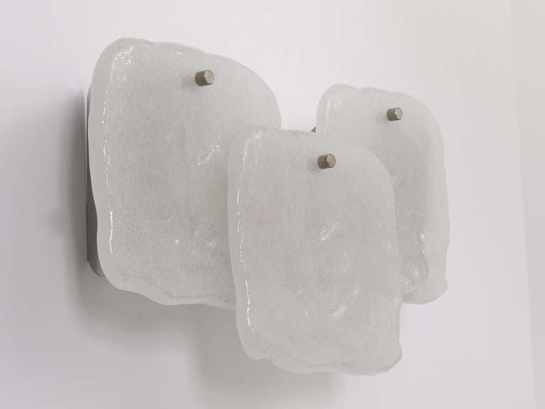 Bis zu vier identische Wandleuchten, hergestellt von Kalmar Austria in den 1960er Jahren. Verchromte Sockel, jede Leuchte ist mit drei quadratischen Eisglasscheiben (7 x 7 Zoll) versehen. In ausgezeichnetem Zustand. Die Wandleuchter haben jeweils