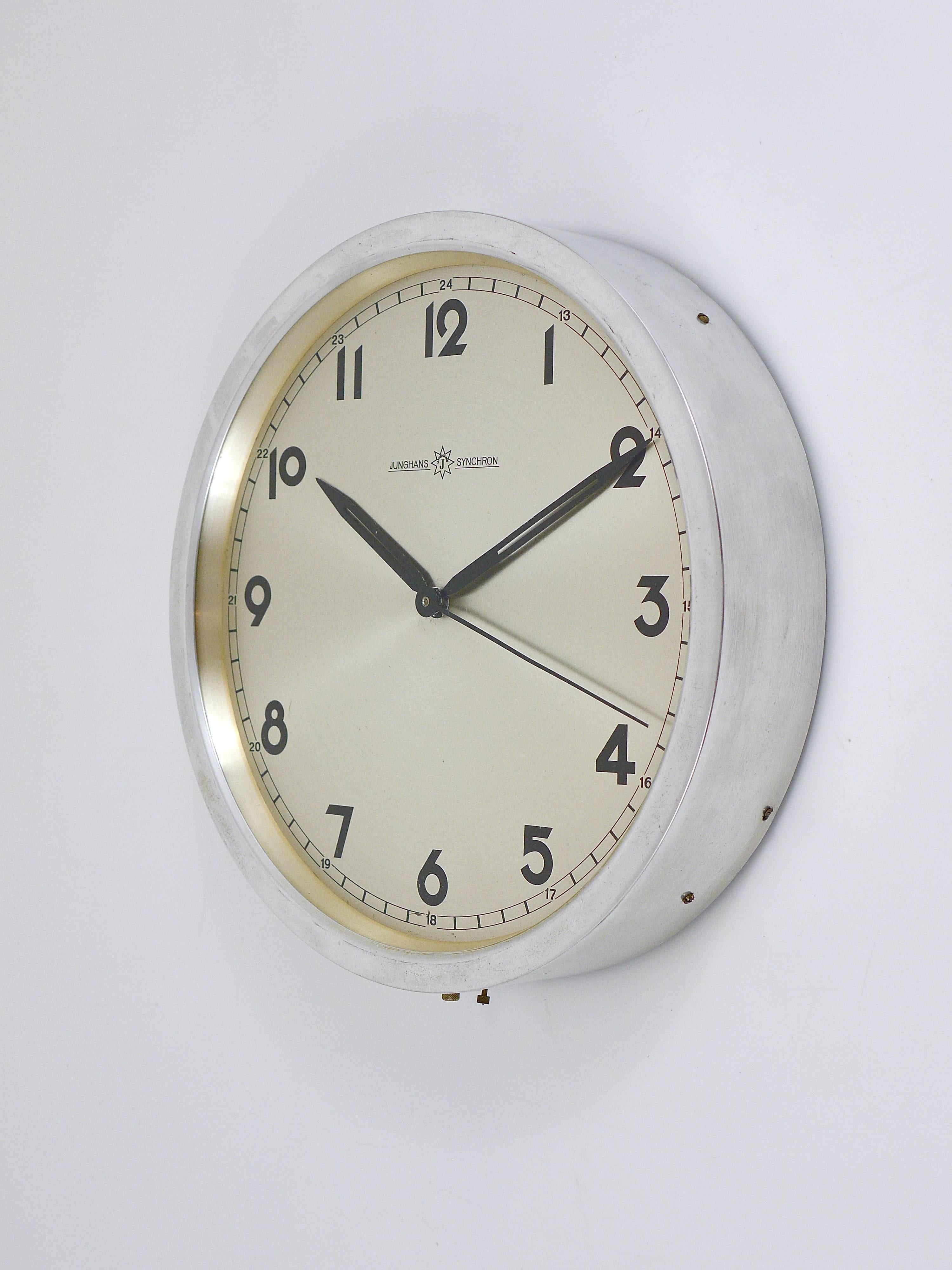 A round modernist wall clock with a beautiful clocks face and an aluminium housing, executed by Junghans Germany in the 1950s. Has still its original electromechanical movement (220V) powered by mains. We offer to replace it with a modern battery