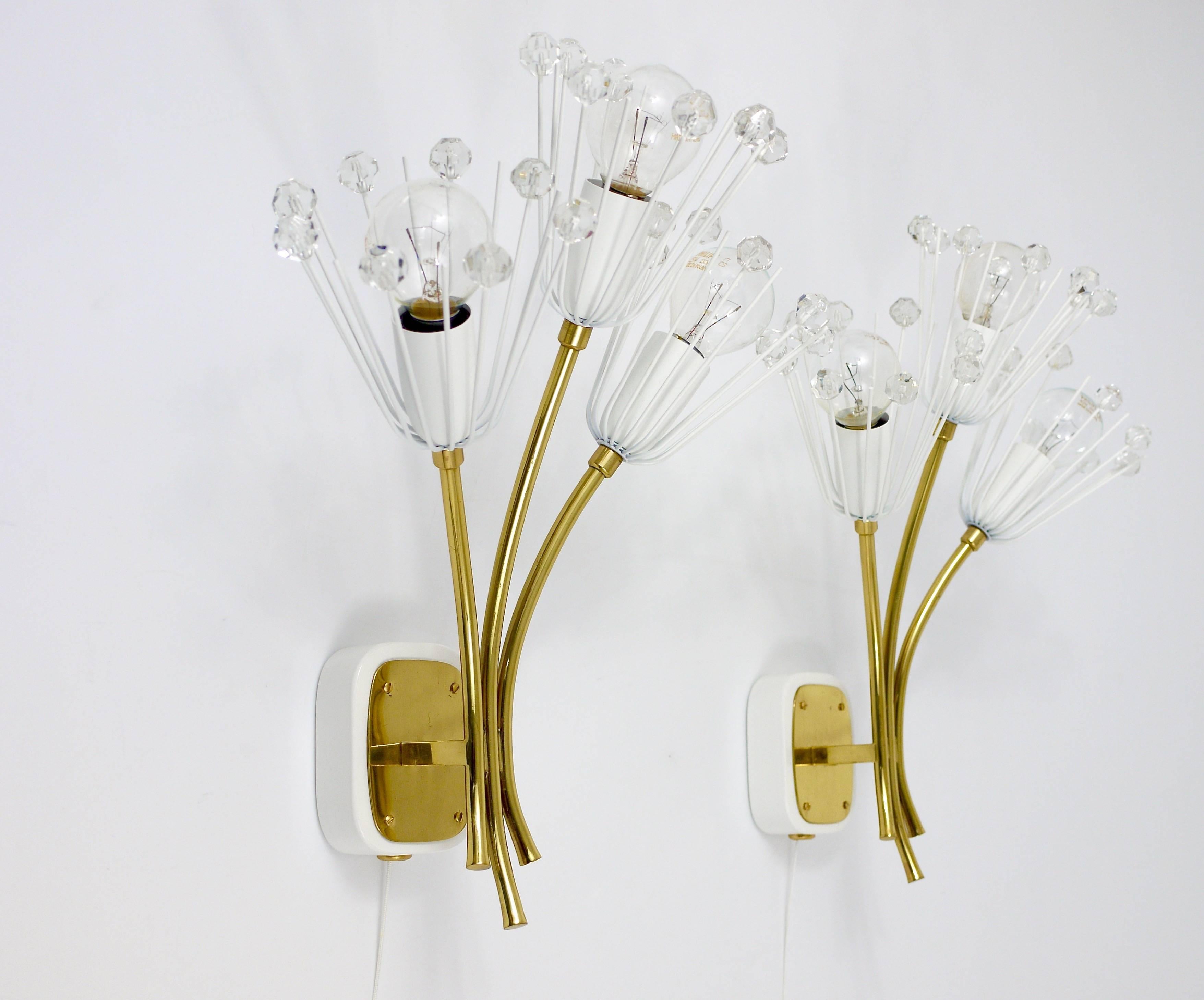 A pair of lovely Austrian floral brass wall lights with three arms, glass crystals and integrated switches. Designed by Emil Stejnar, executed by Rupert Nikoll in the 1950s. Professionally restored and rewired, in very good condition. 

 