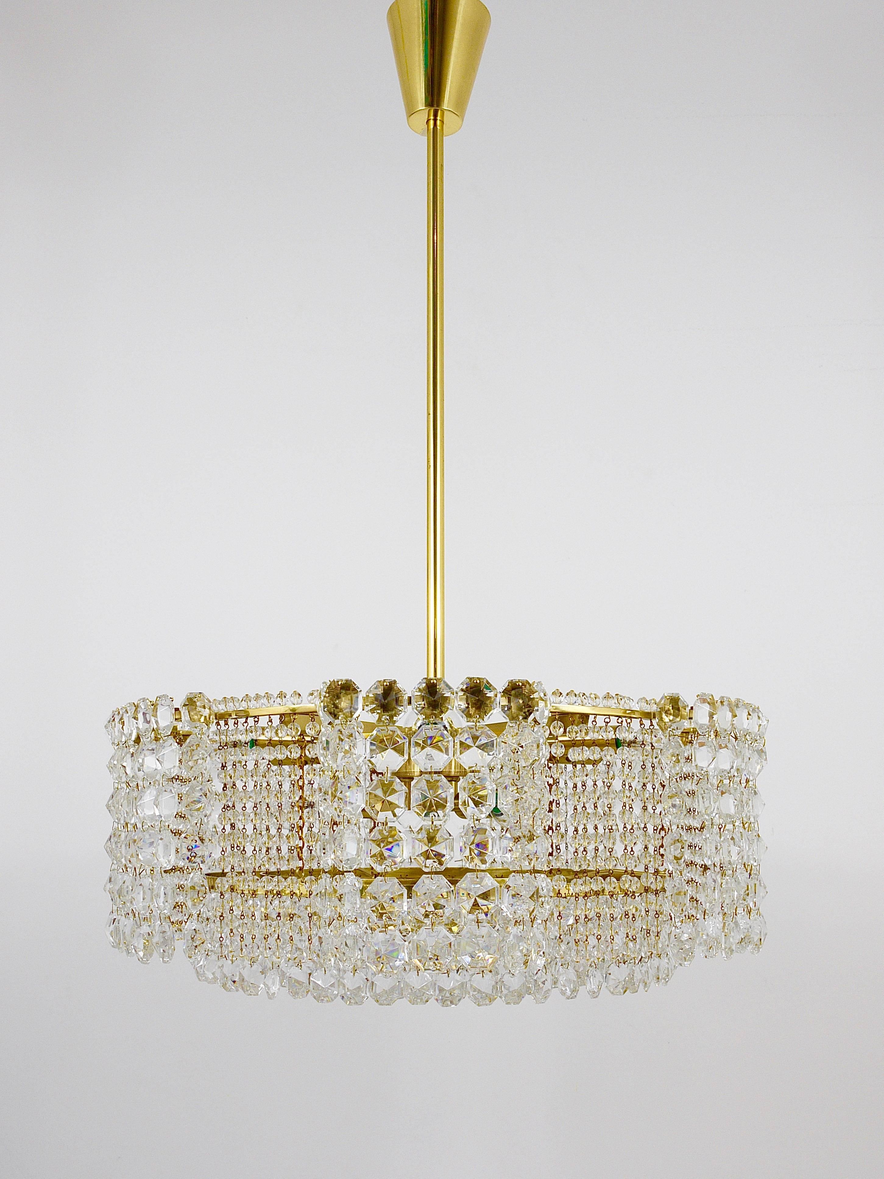 A beautiful and big multi-tiered brass and crystal chandelier by Lobmeyr Vienna from the 1950s. Fully covered by dazzling faceted crystals. This chandelier has nine light sources and has been carefully restored and rewired. In excellent condition.