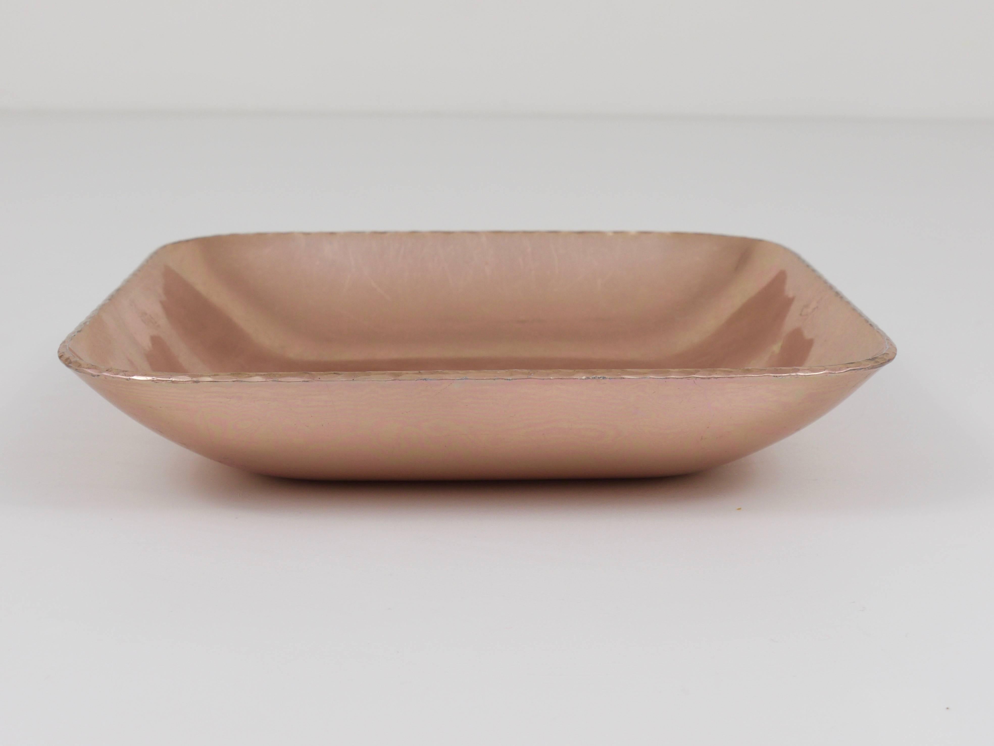 A square, pink-anodized bowl, handmade of aluminum, attributed to Fritz August Breuhaus de Groot. Executed by Zeppelin Metallwerke in the early 1930s, made as tableware for the Zeppelin airships, but very suitable as a jewelry bowl or vide-poche. 