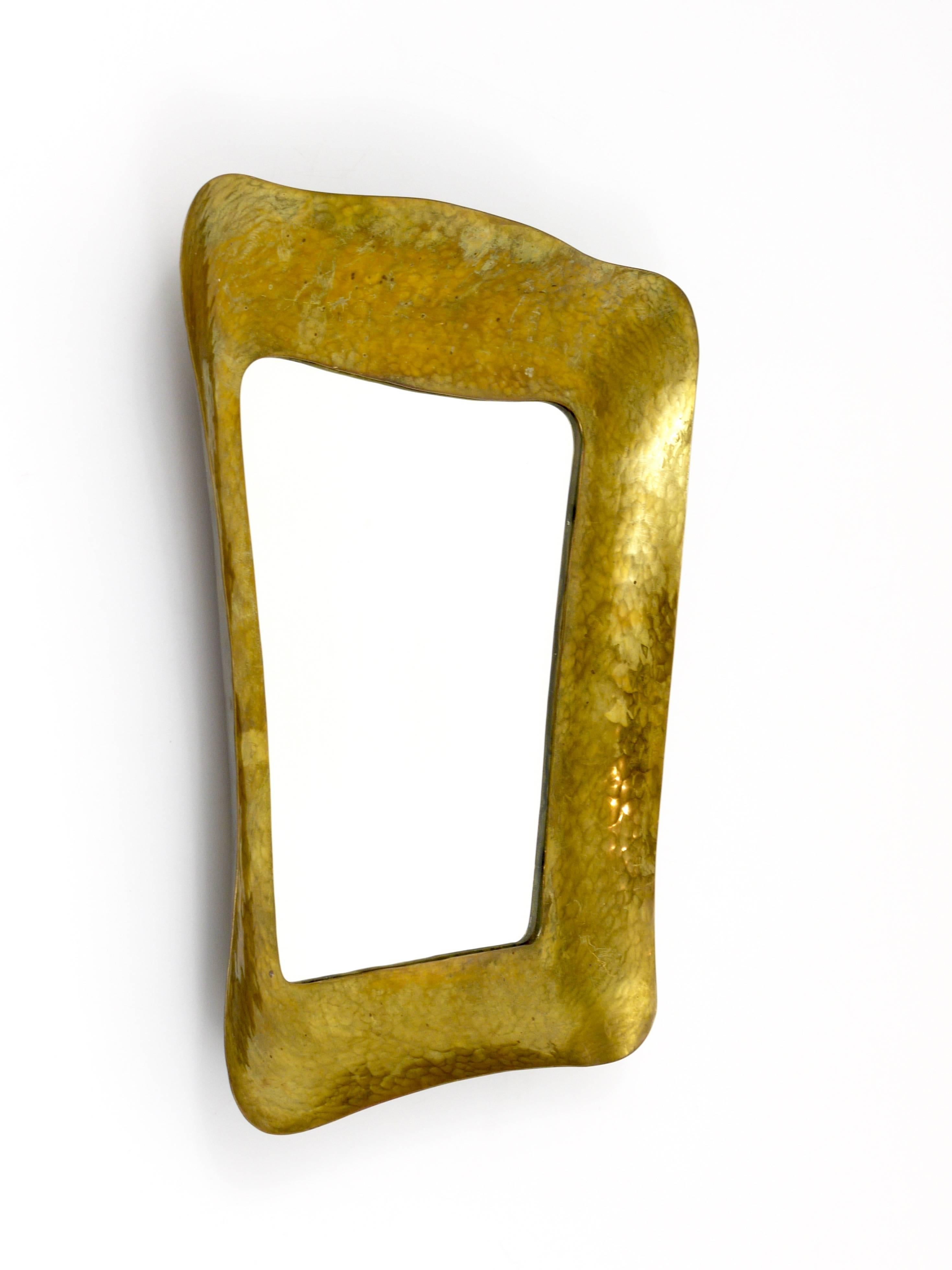 A beautiful handcrafted, hammer-blown modernist wall mirror, made of brass. Made in Austria in the 1950s. In excellent condition with nice patina.
