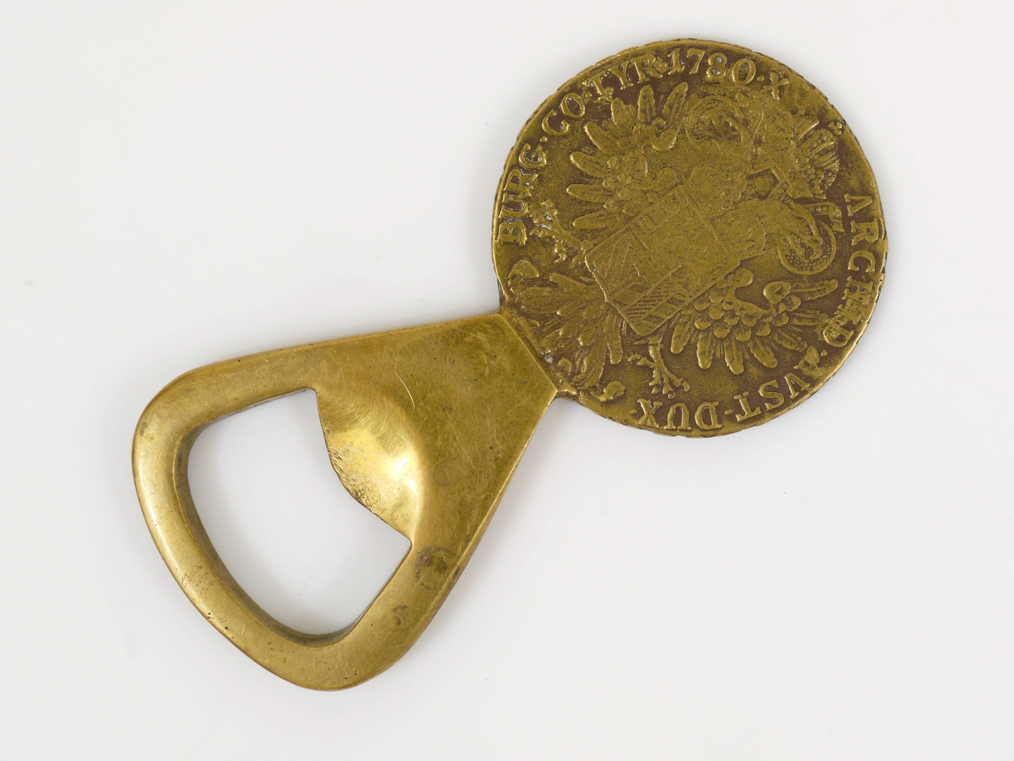 A beautiful brass coin bottle opener, designed and executed by Carl Aubock in the 1950s. In good condition with nice patina. 